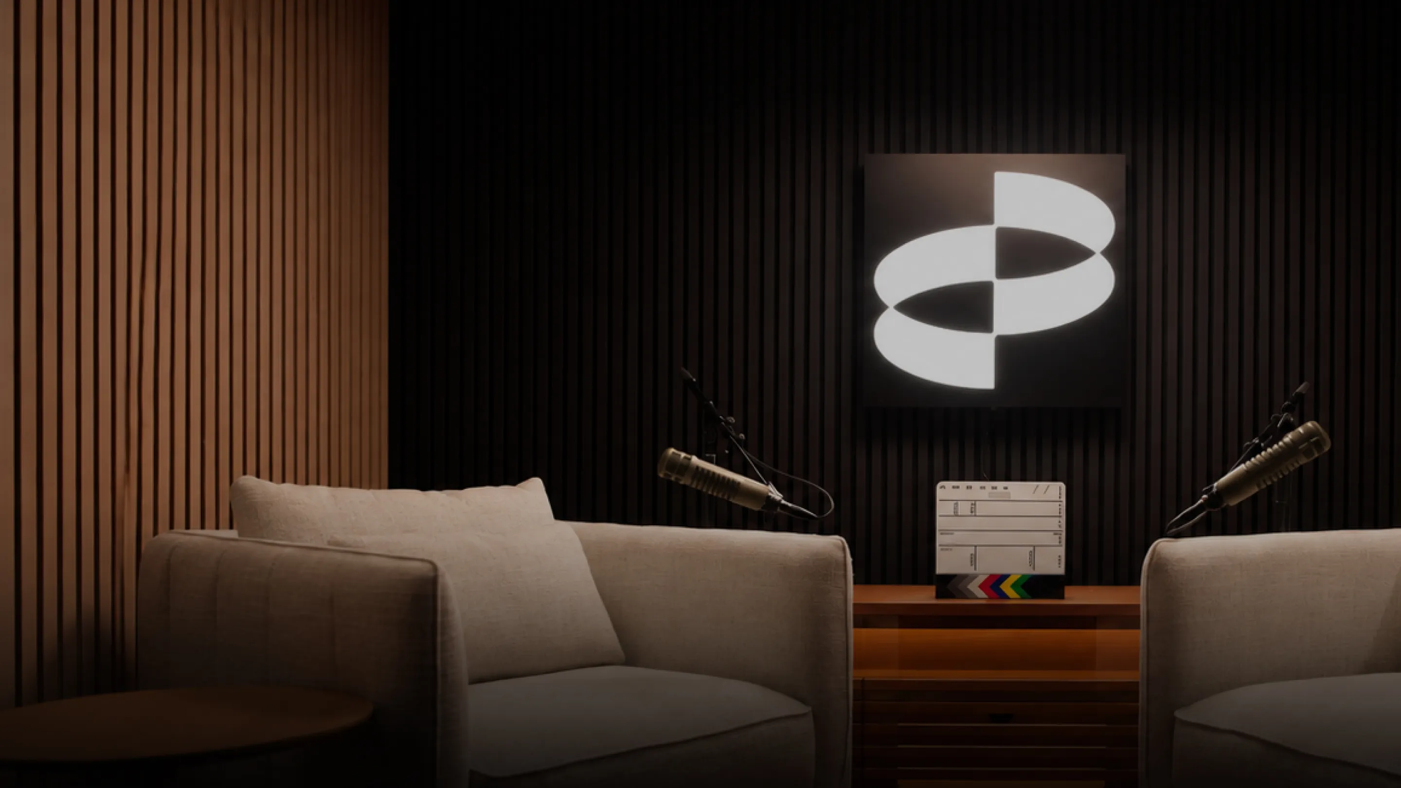 Podcast studio of The Agentic Wave with two armchairs, microphones and an illuminated Parloa logo on the wall