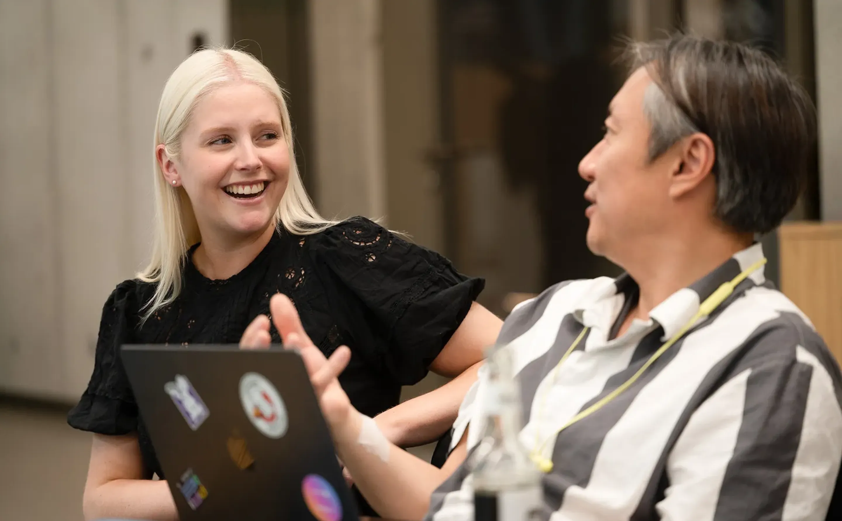 Two colleagues laughing in conversation
