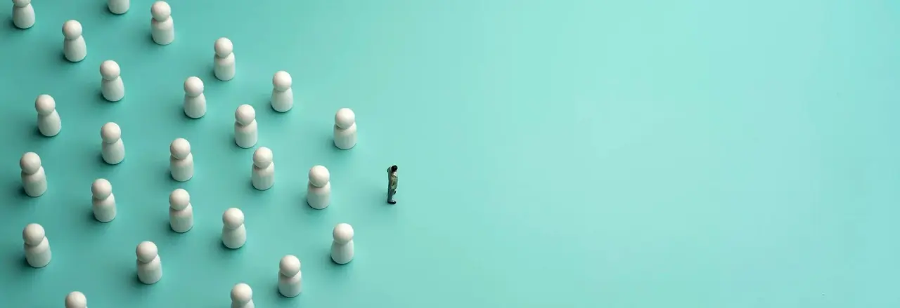 A lone figure faces a group of white game pieces arranged in formation on a teal background, symbolizing leadership or confrontation.