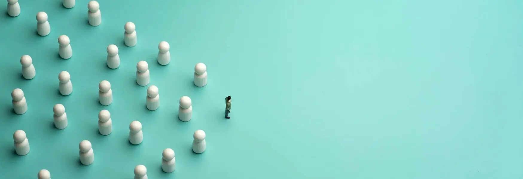 A lone figure faces a group of white game pieces arranged in formation on a teal background, symbolizing leadership or confrontation.