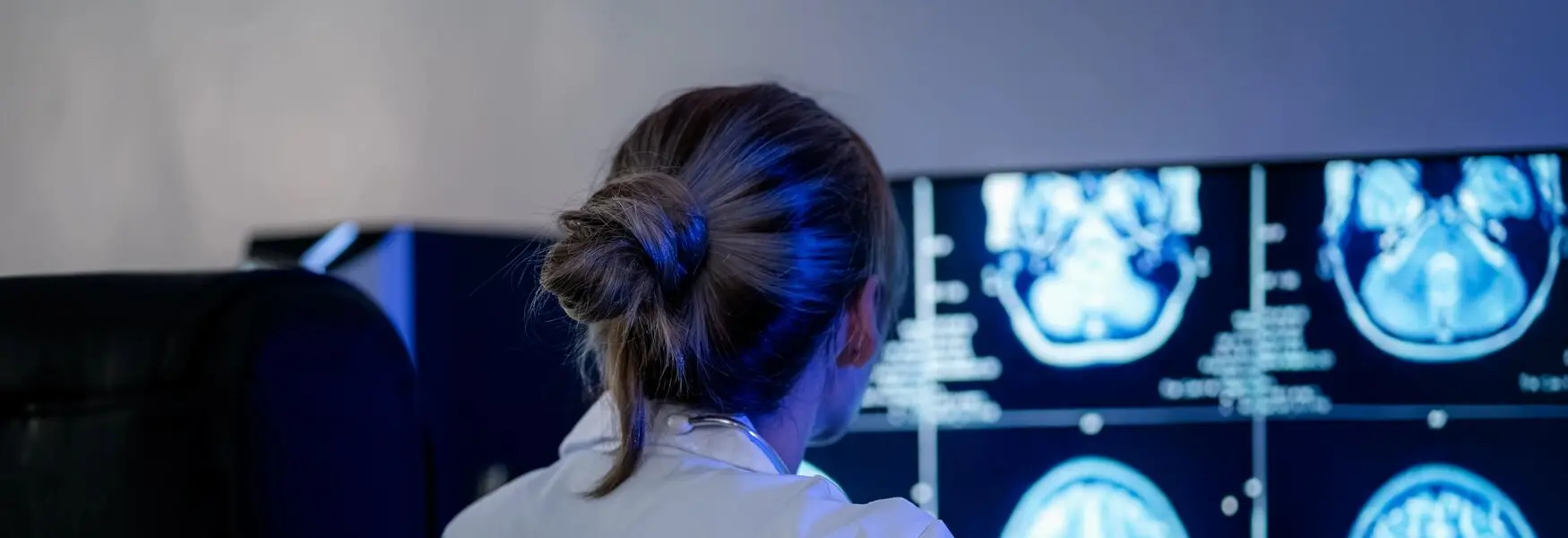 girl-with-hairbun-sitting-in-front-of-a-screen-