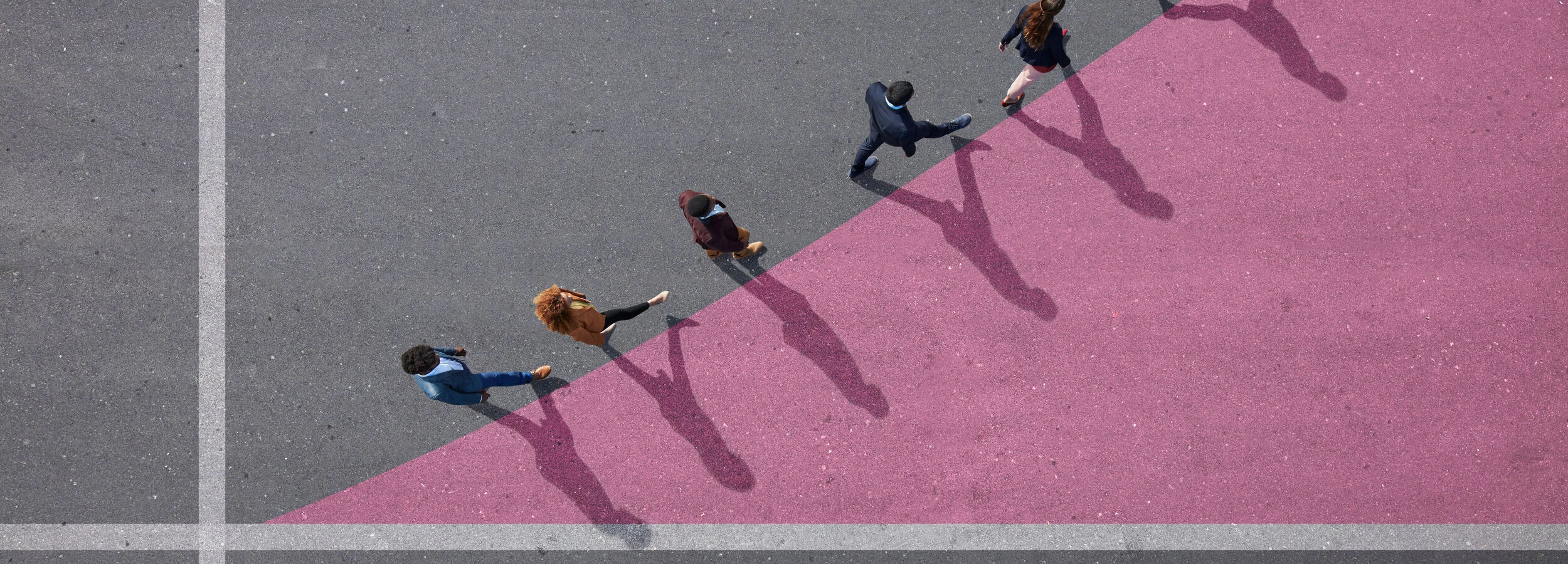 Group of young adults, photographed from above, on various painted tarmac surface, at sunrise.