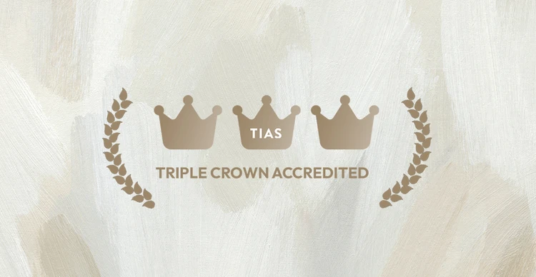 Three crowns labeled "TIAS Triple Crown Accredited" with laurel branches on a textured beige background.