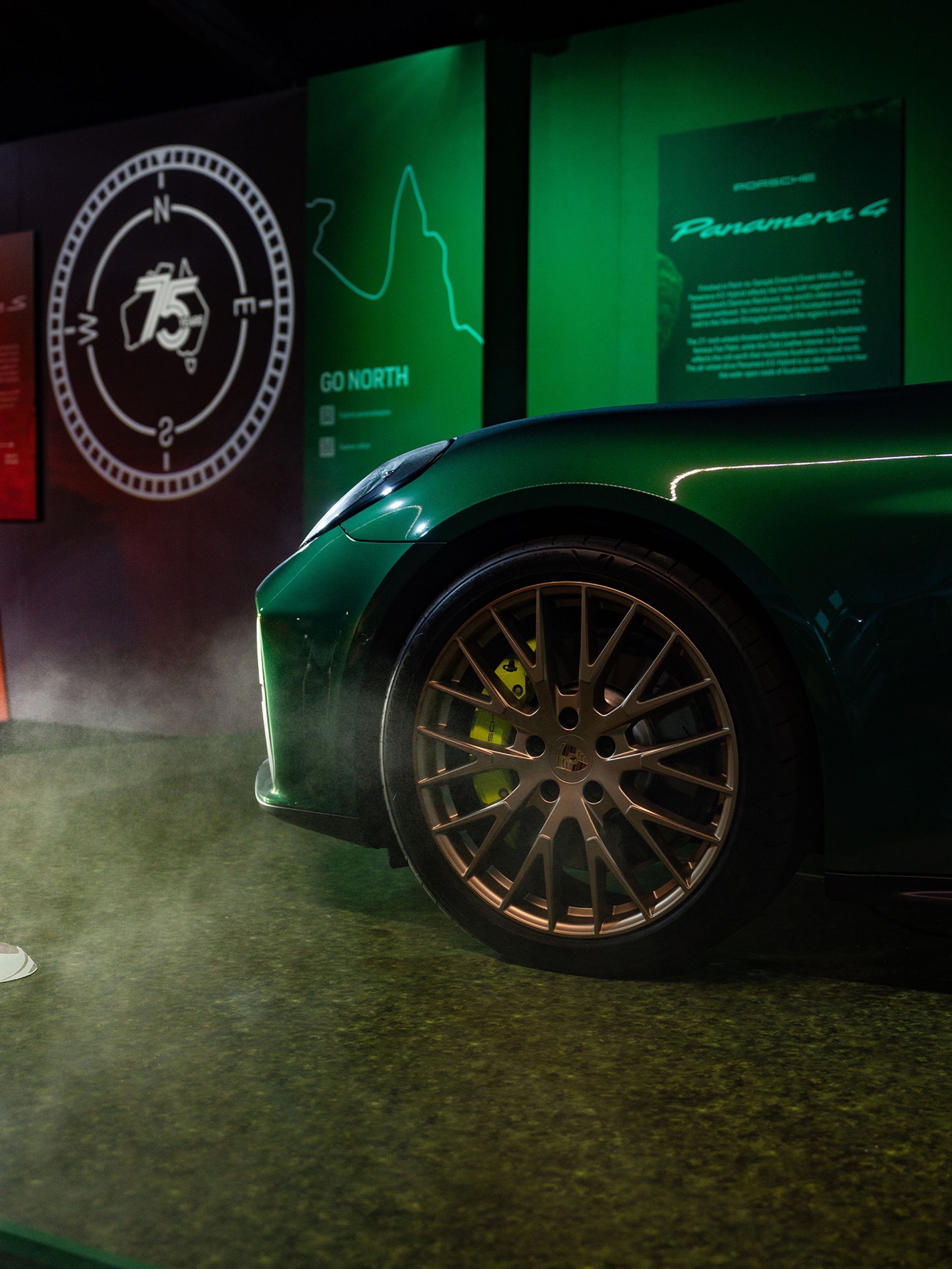 Tire shot of a green Porsche standing in front of info walls.
