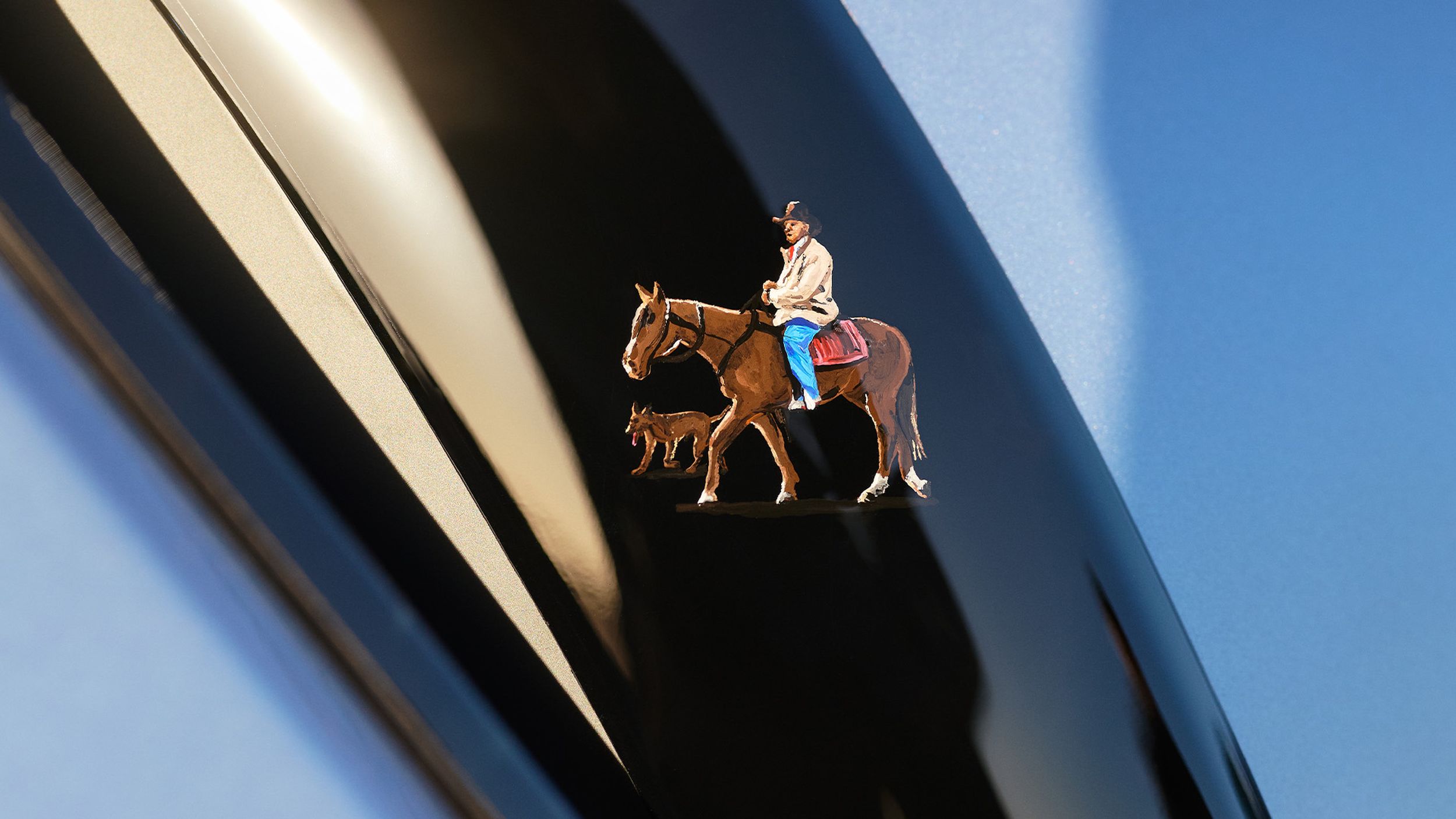 Decal of a horseback-riding man with a dog.