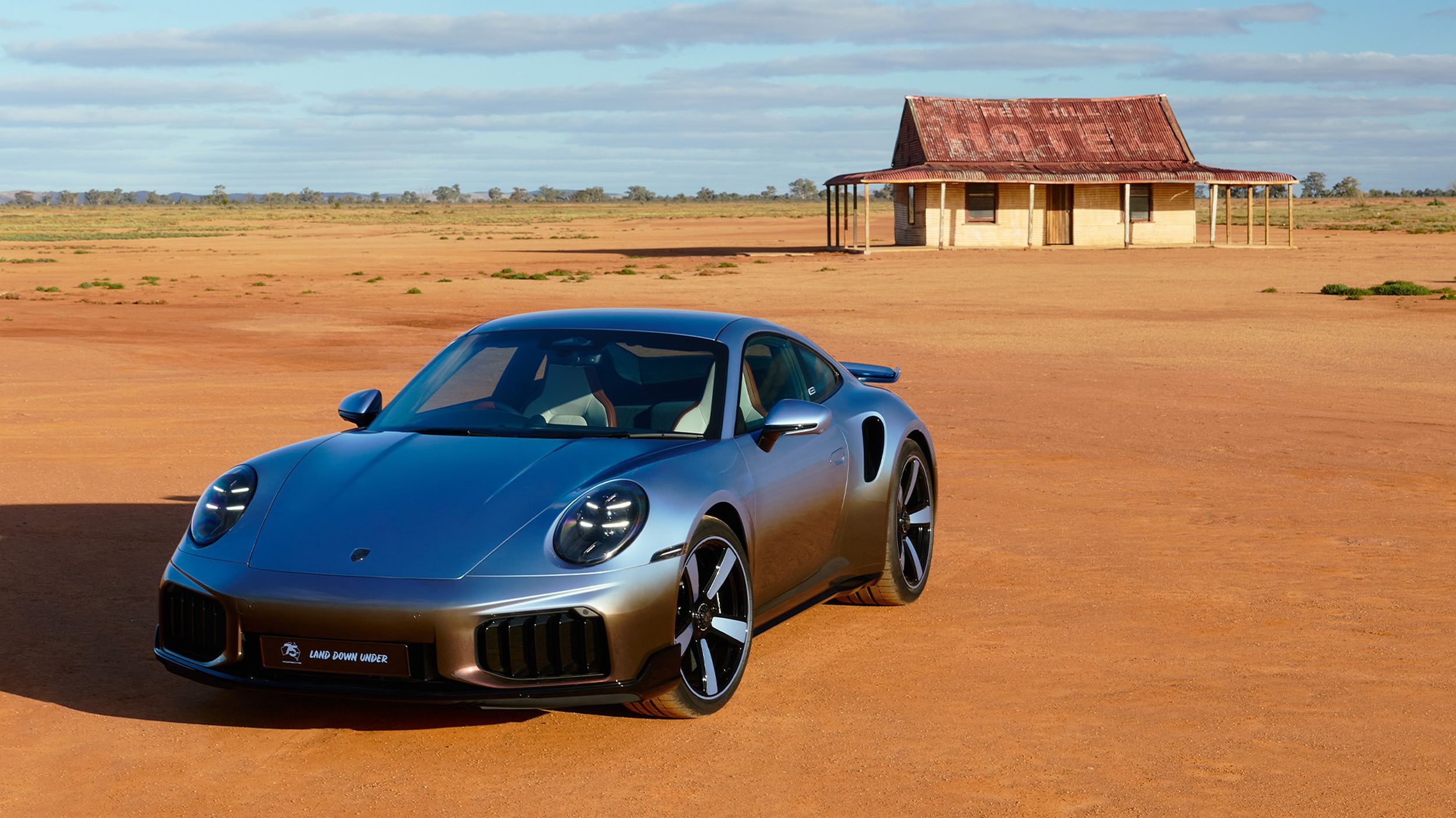 Frontal shot of the 911 Turbo S Land Down Under in front of a hut.