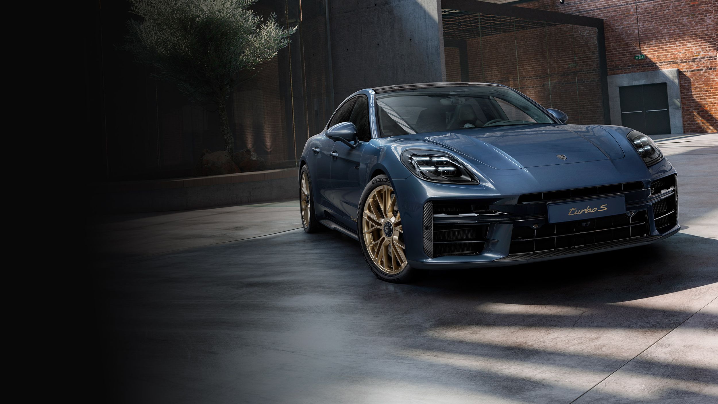 Front view of the front of the Porsche Exclusive Manufaktur Panamera Turbo S E-Hybrid in Yachting Blue Metallic with Aerokit Carbon.