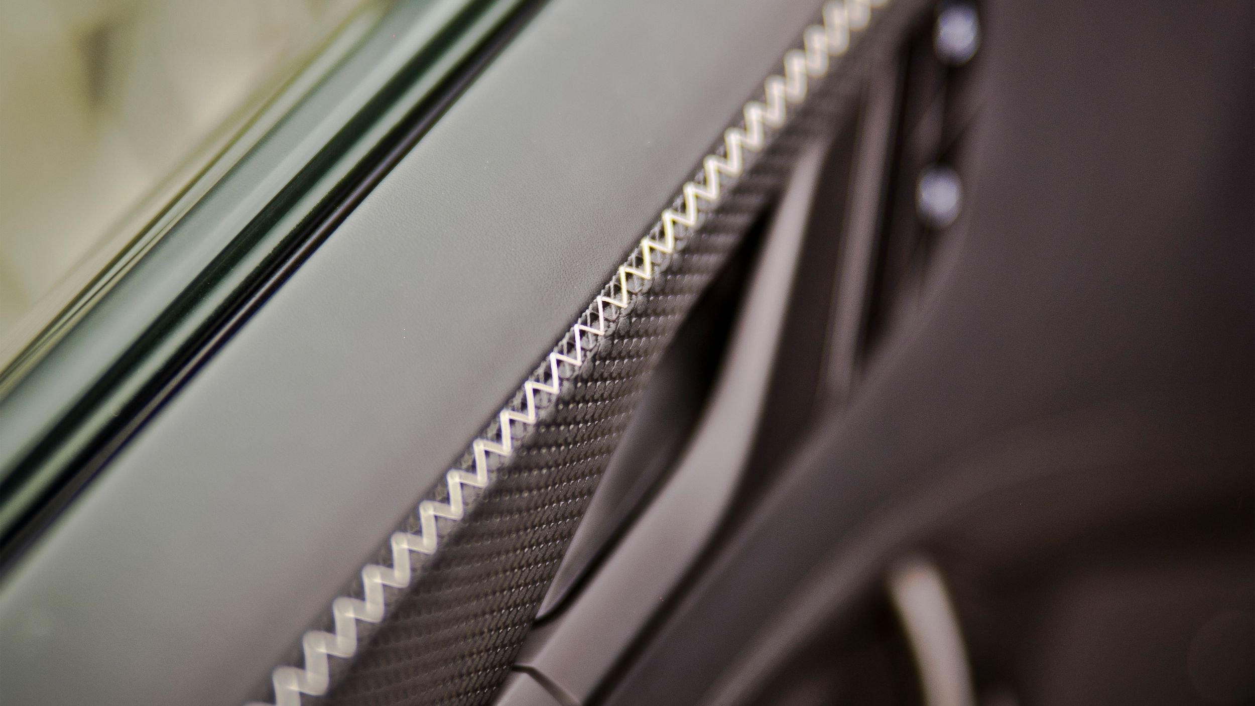Nahaufnahme der Porsche 911 GT3 Bergsport Türverkleidung mit Carbon-Inlay  und weißer Zickzack-Naht.
