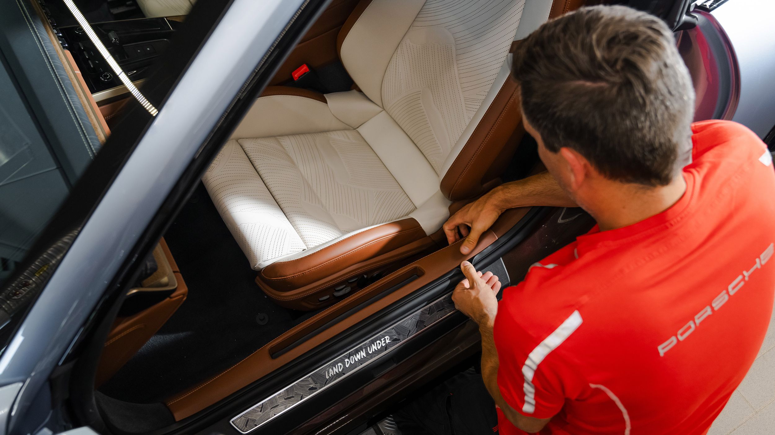 A Porsche mechanic working on the interior of the Porsche 911 Turbo S Land Down Under.