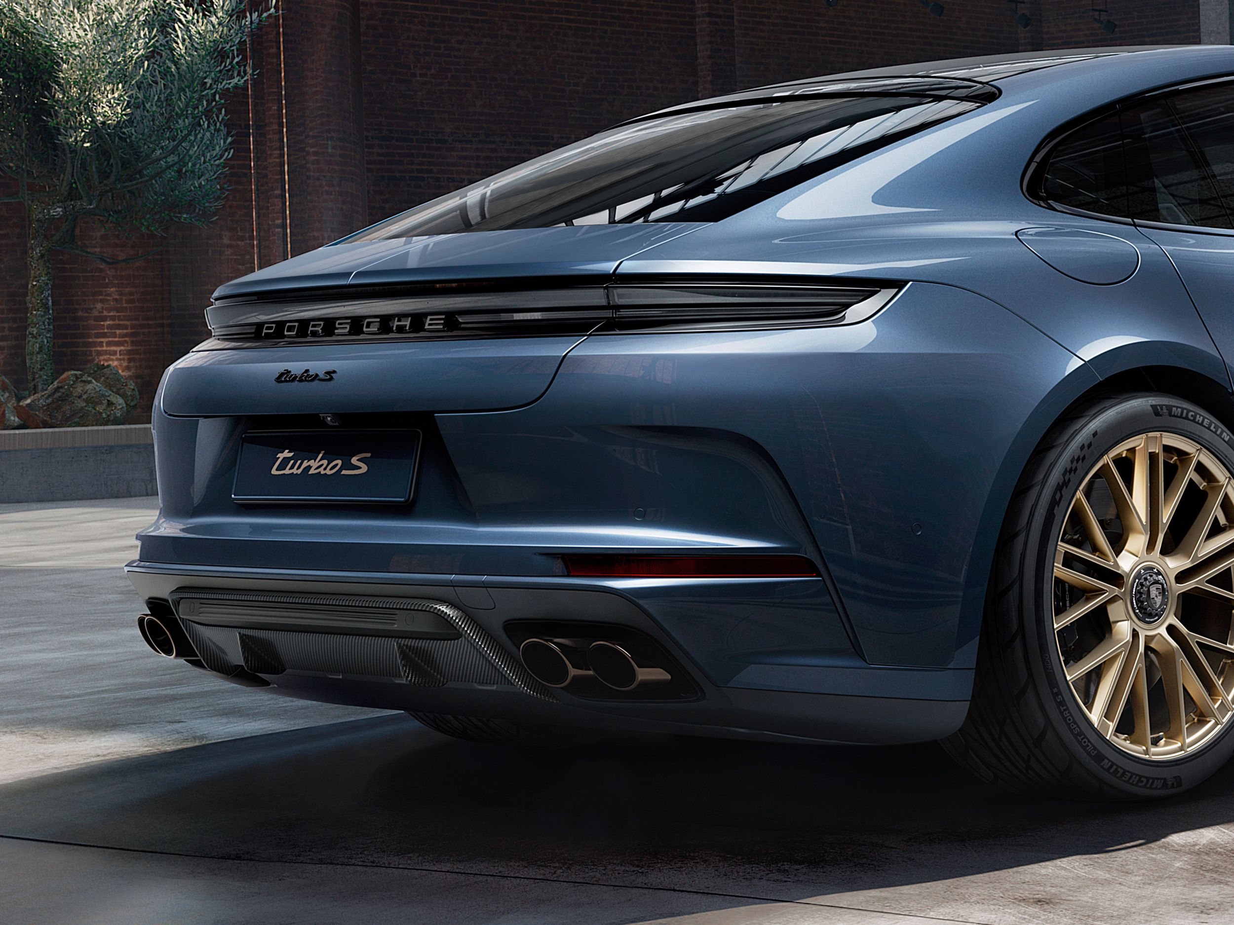 Side view of the rear end of the Porsche Exclusive Manufaktur Panamera Turbo S E-Hybrid in Yachting Blue Metallic.