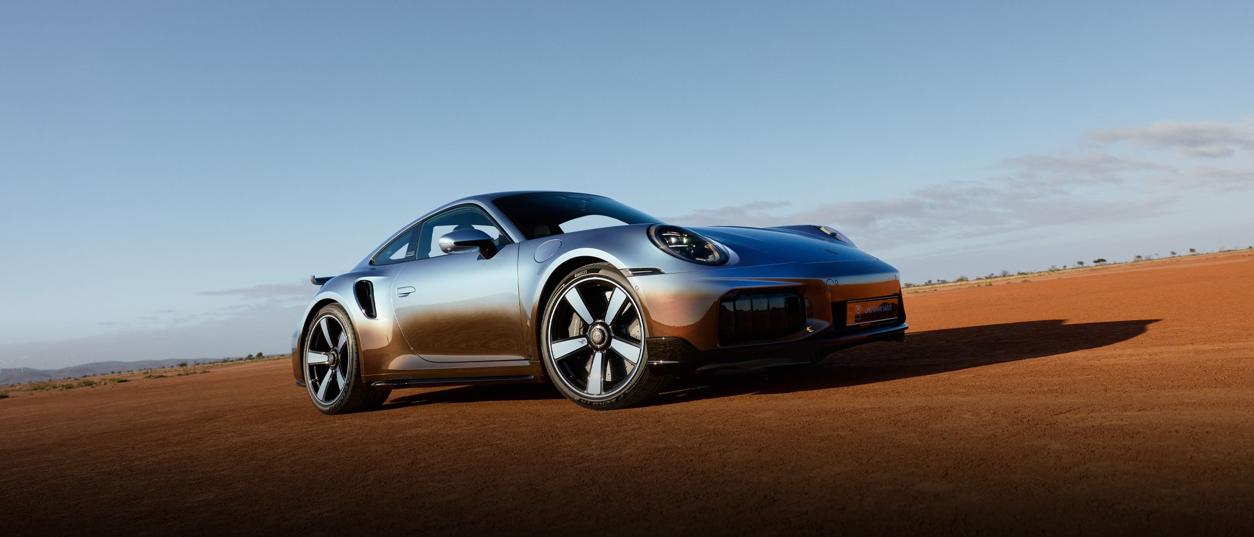 Frontal side shot of the Sonderwunsch Porsche 911 Turbo S Land Down Under in a desert environment.