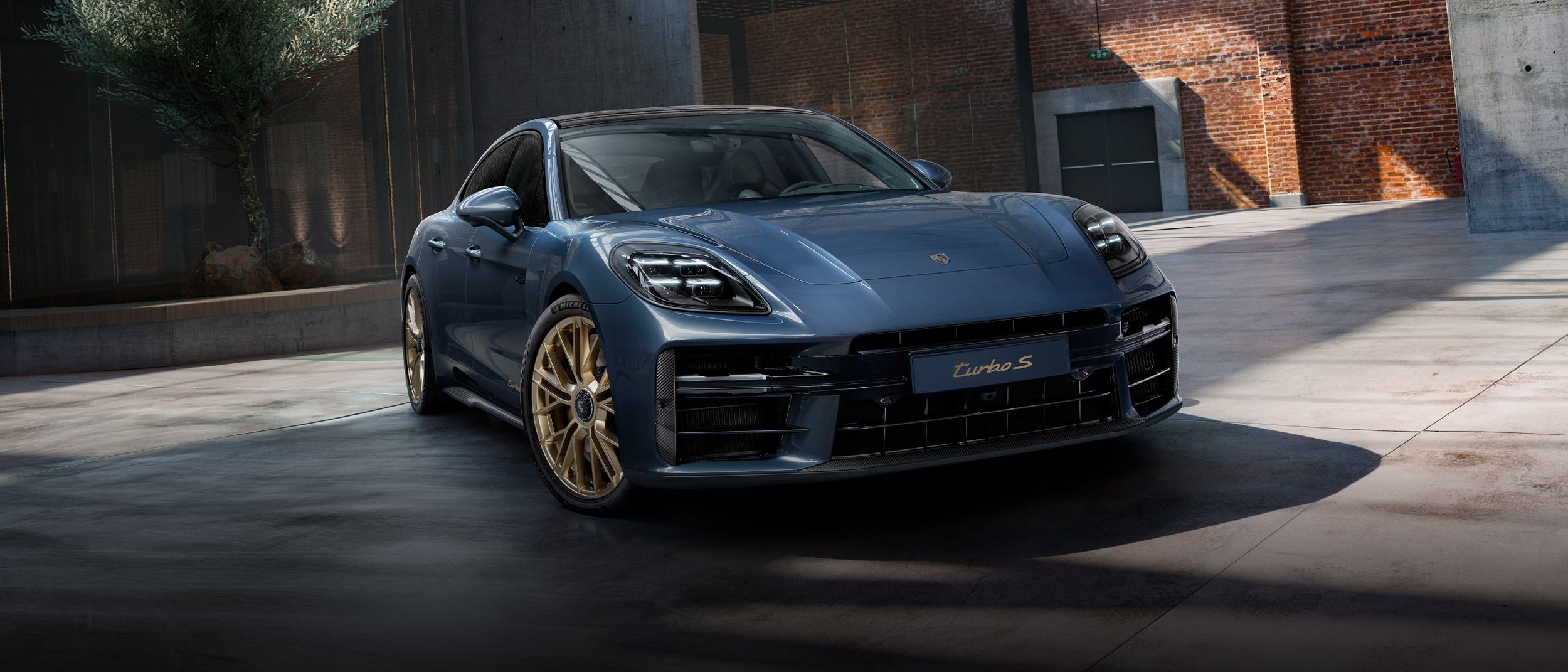 Front view of the front of the Porsche Exclusive Manufaktur Panamera Turbo S E-Hybrid in Yachting Blue Metallic with Aerokit Carbon.