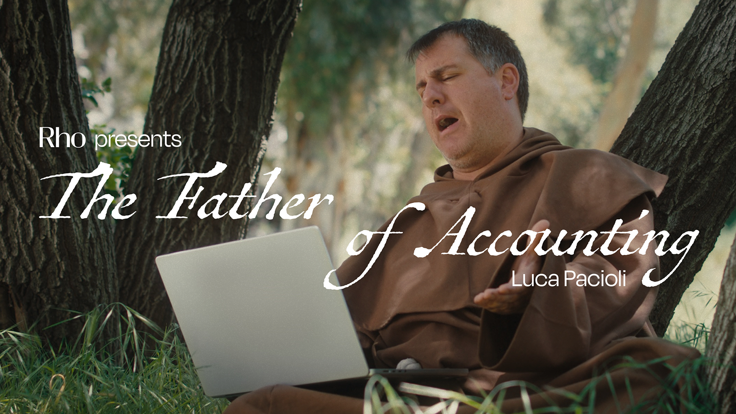 A man in a brown robe sits outdoors with a laptop, eyes closed, under the text "The Father of Accounting, Luca Pacioli."