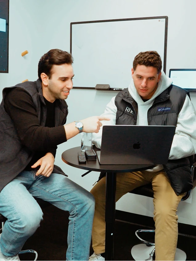 two people working on a laptop
