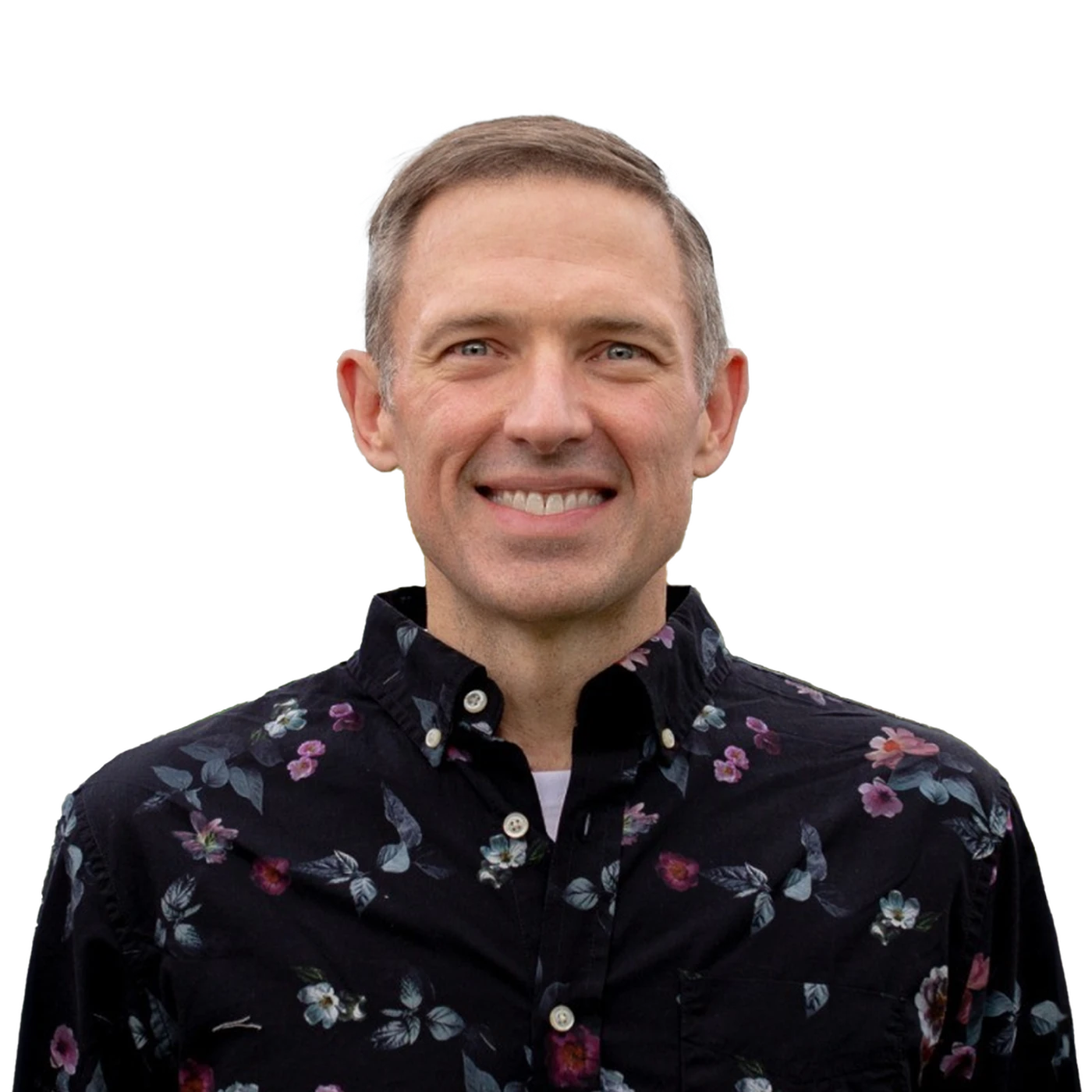 Smiling person wearing a black floral shirt against a plain background.