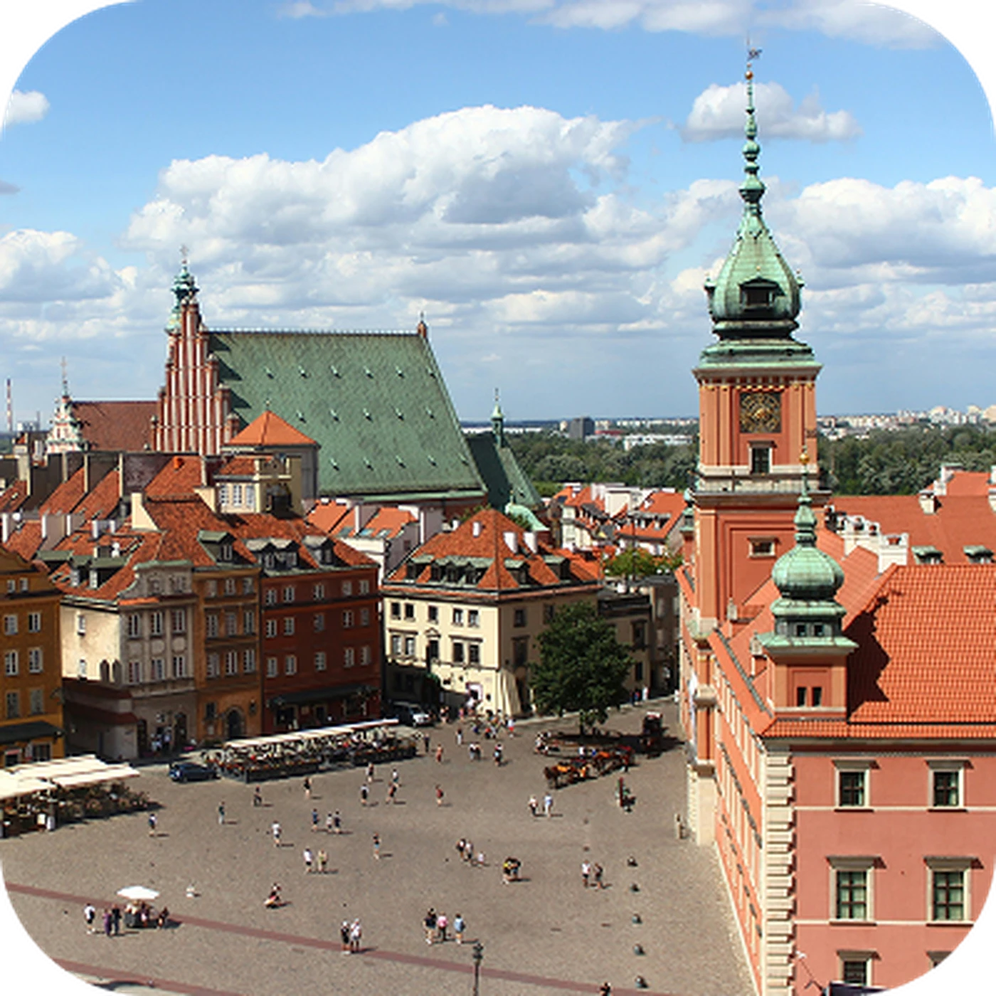 Aerial view of a historic European square with colorful buildings, a church, and a tower under a partly cloudy sky.