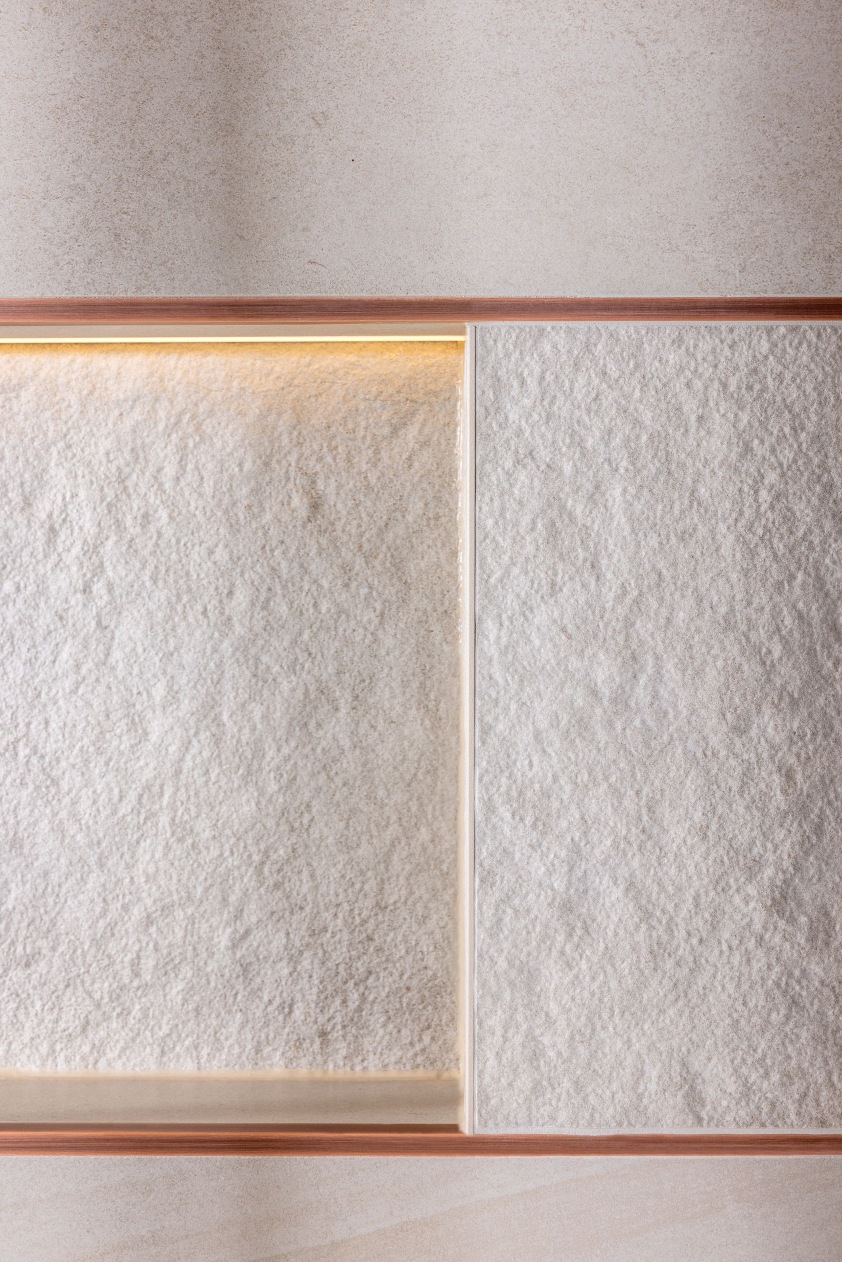 Detail van wandtegels (Sunrise Grey) met geïntegreerde nis en subtiele LED-verlichting, afgewerkt met een smal profiel.