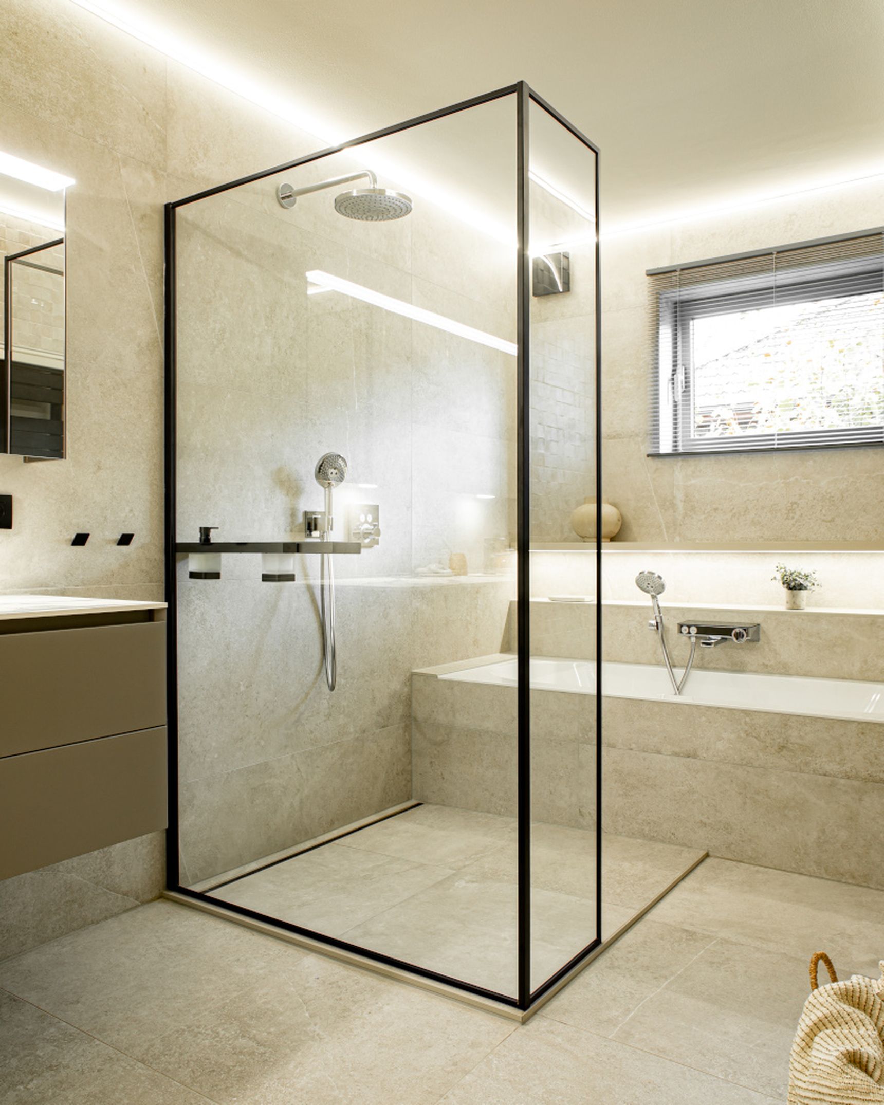 Modern bathroom with glass shower enclosure, beige tiles, a bathtub, and a window with blinds. Soft lighting enhances the sleek design.