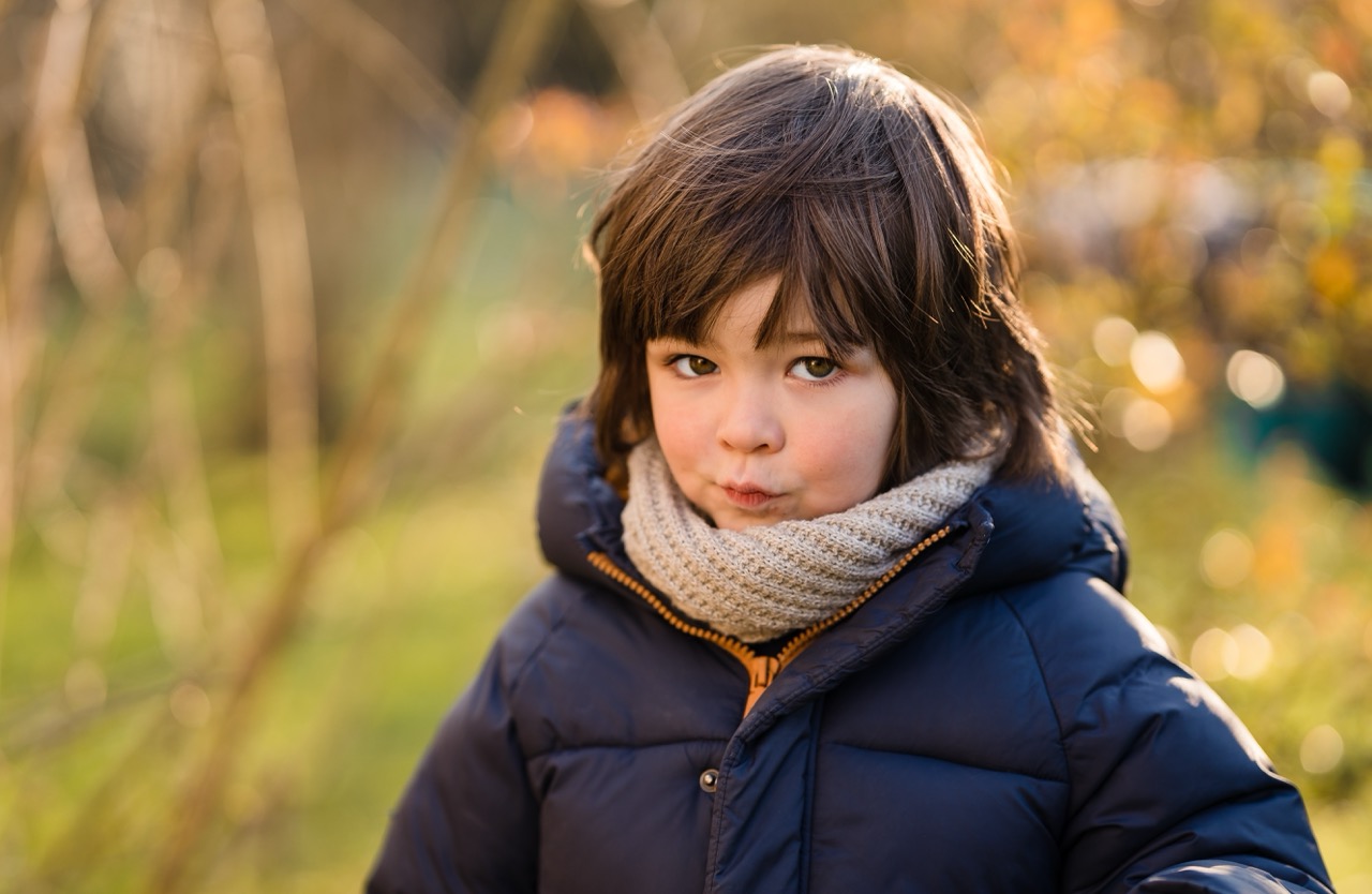 Jonge jongen buiten in een winterjas