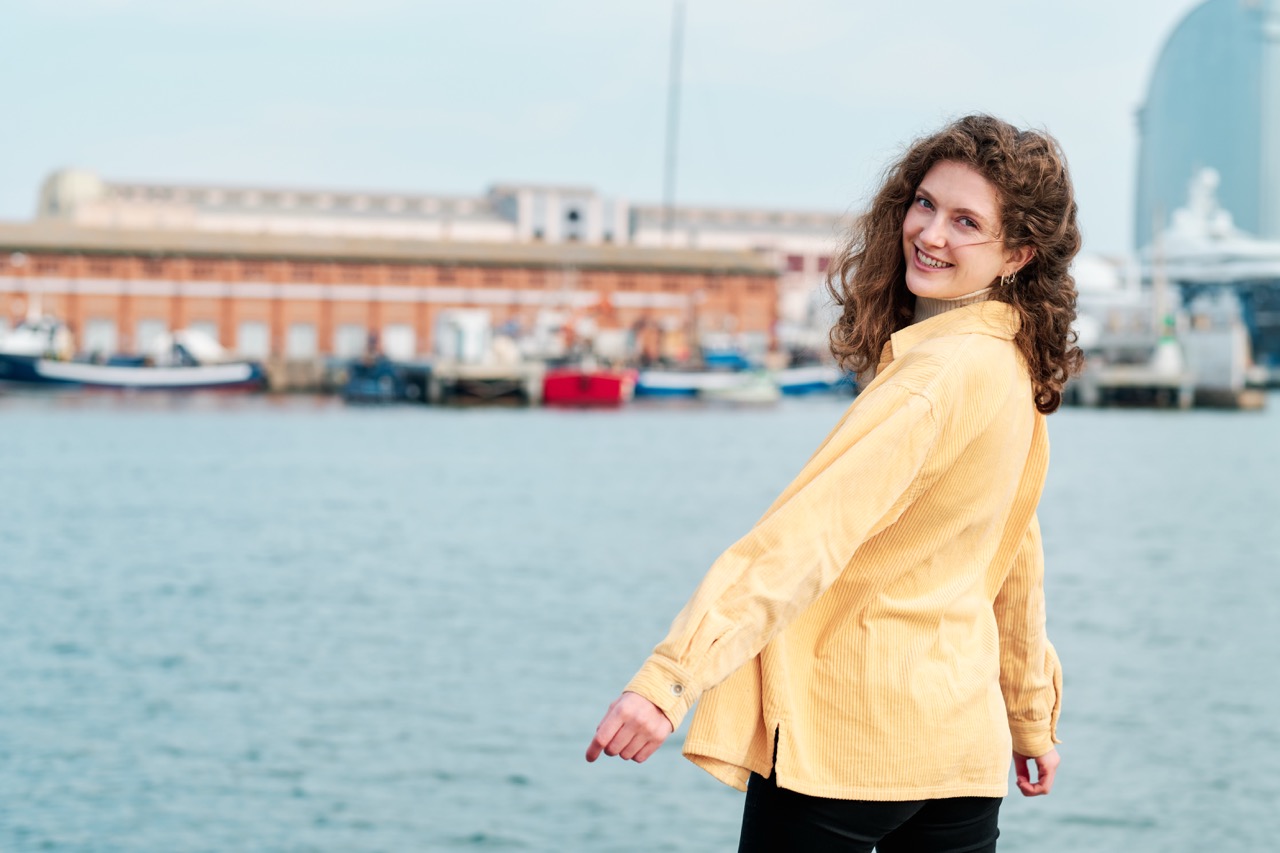 Jonge vrouw buiten in de zon met een zomerjas