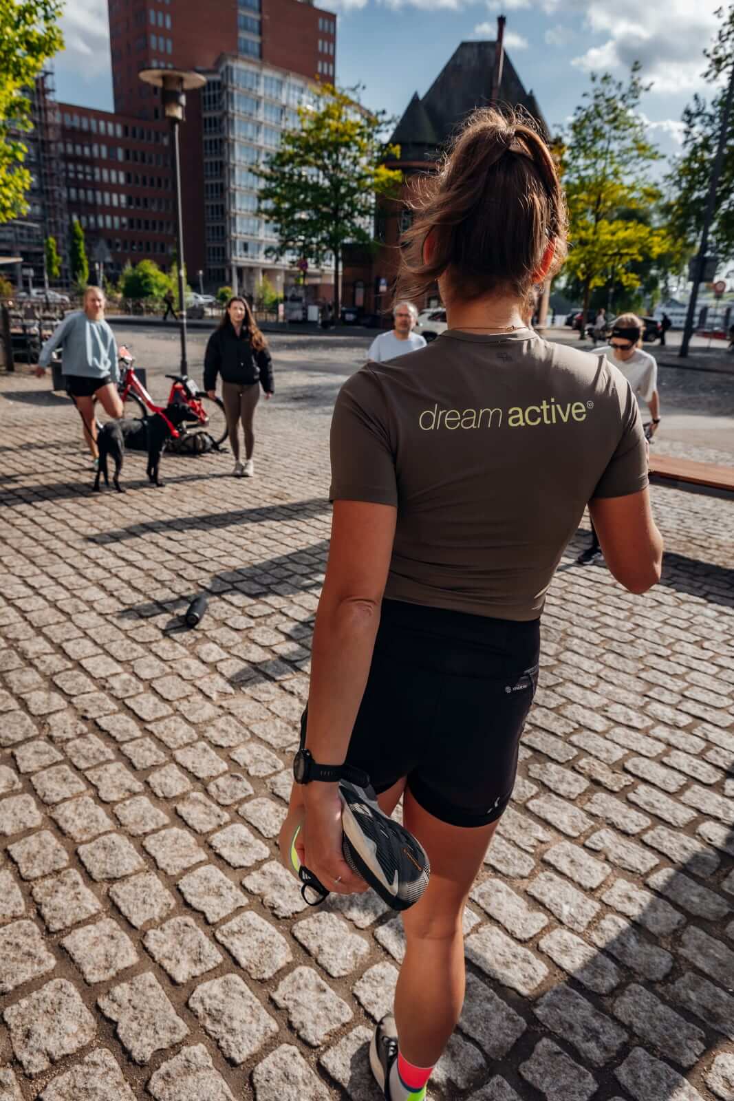 Rückenansicht einer Läuferin im dream active-Shirt auf Kopfsteinpflaster in Hamburg