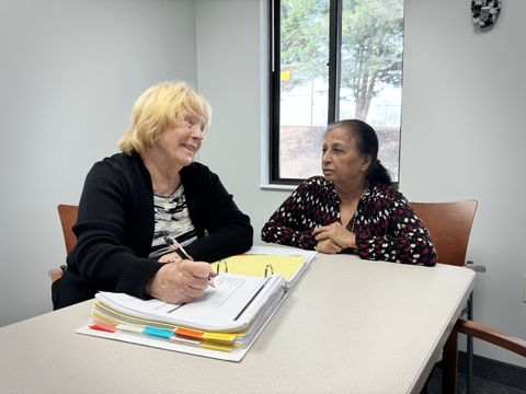 A social worker from Jupiter's staff meets with a participant in a conference room.