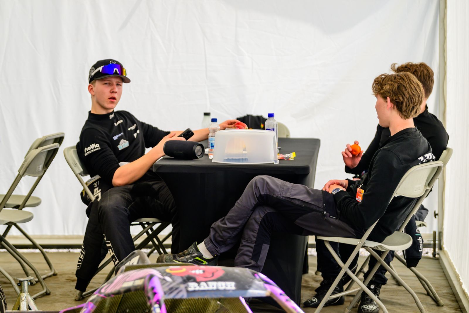Three drivers sat on plastic chairs around a table