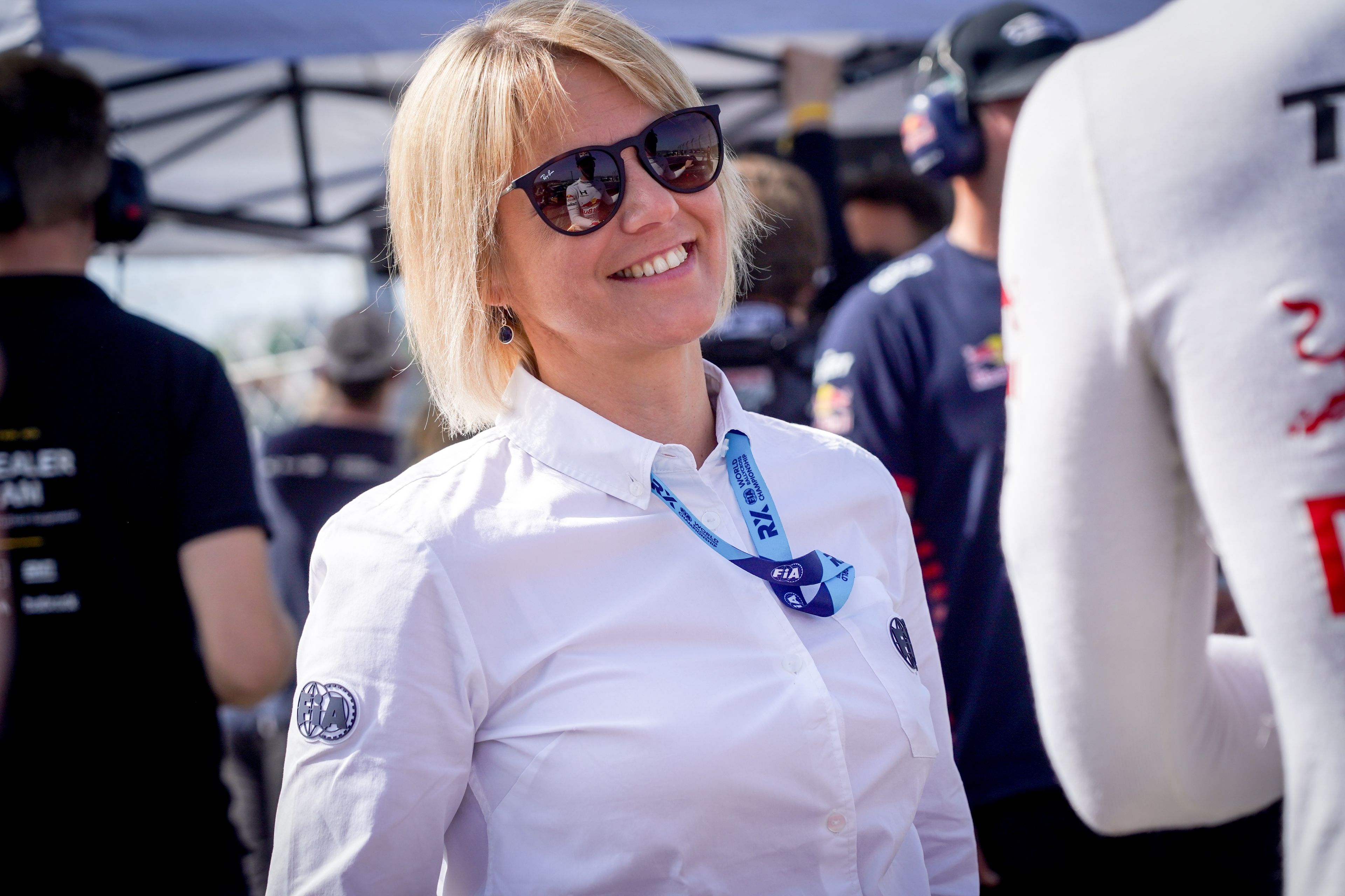 A woman in sunglasses and FIA uniform