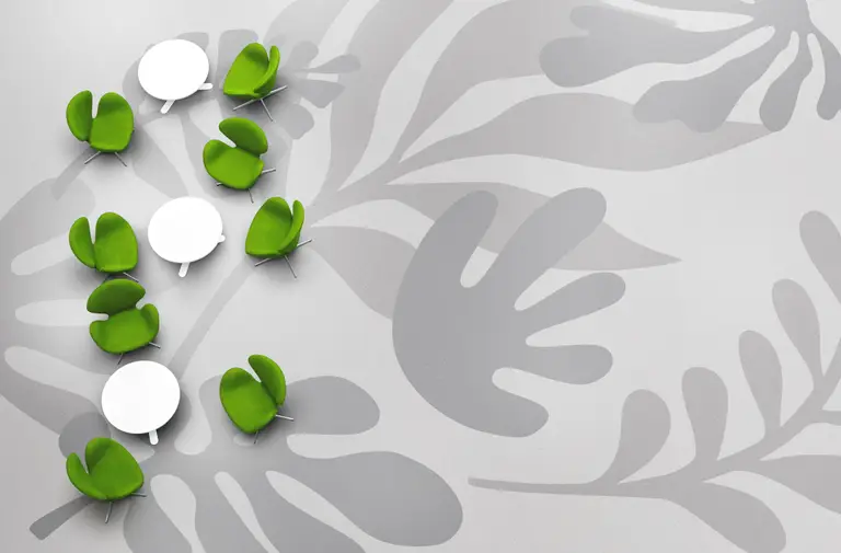 Green chairs and white tables arranged on a gray floor with large leaf patterns, creating a modern and artistic design.