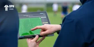 Análisis táctico con IA en el fútbol donde un entrenador usa una tableta con gráficos
