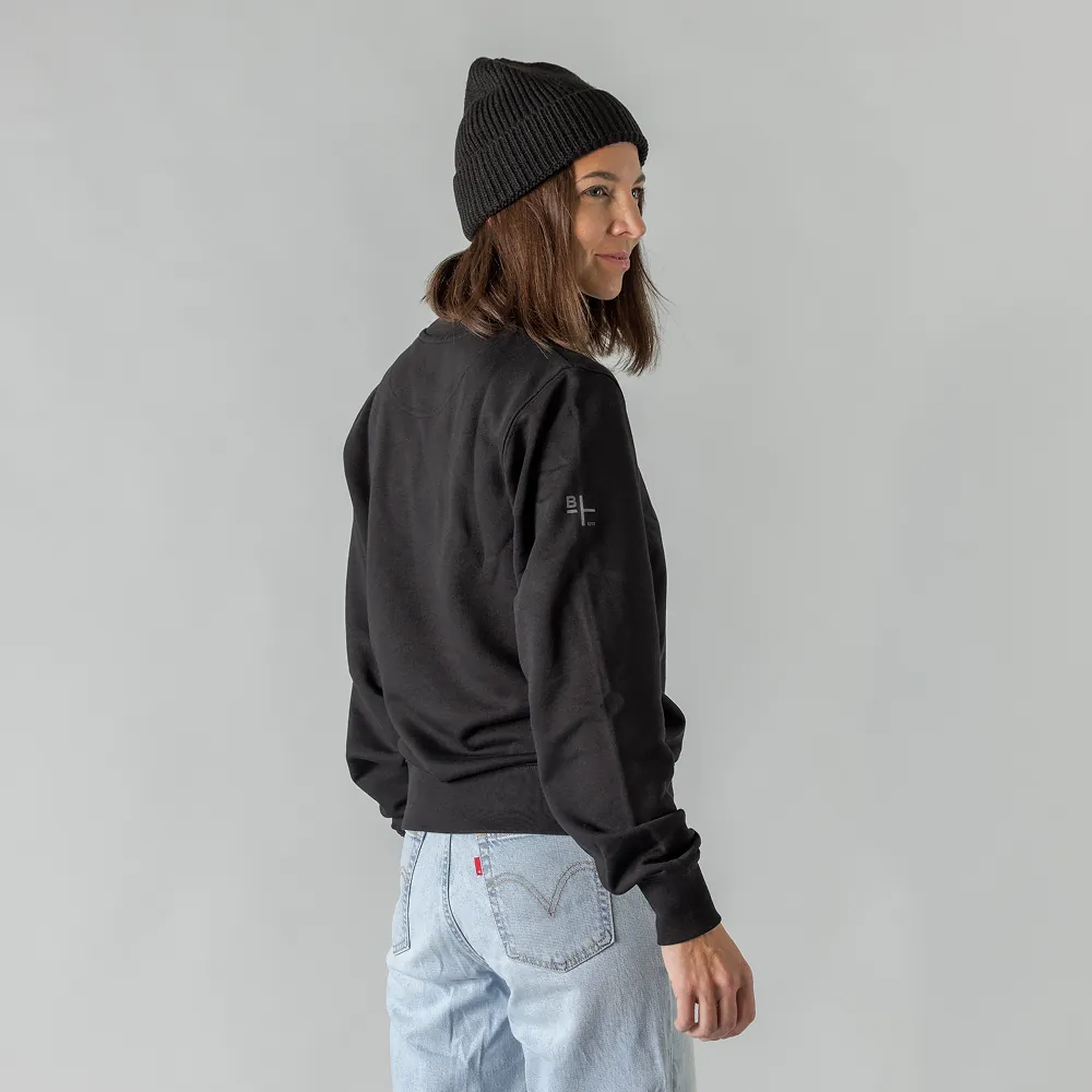 Frau mit schwarzer Beanie und schwarzem Sweater von hinten mit BIXS Logo am Arm