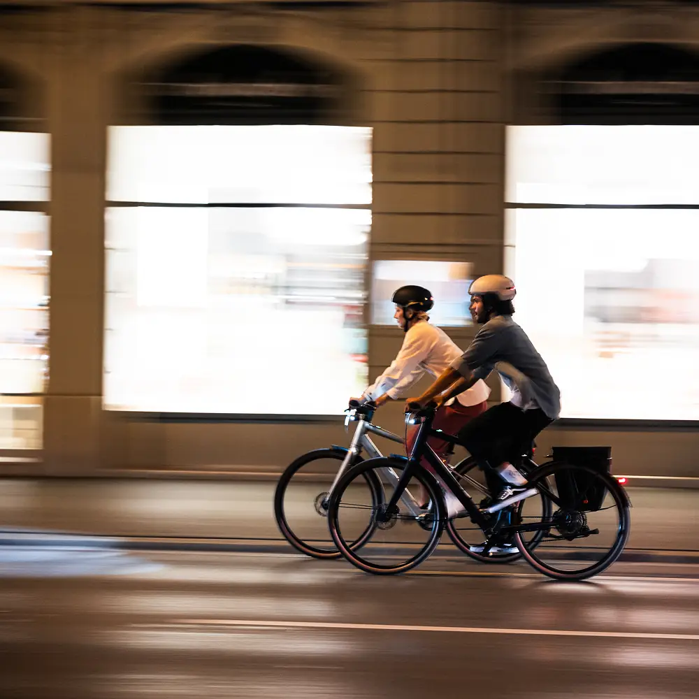 Zwei Fahrer auf BIXS Urban-Bikes bei Nachtfahrt in Bewegungsunschärfe