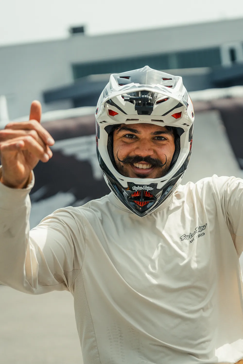 Vitor Buechli, BIXS Mindsetter, mit weissem Fullface-Helm, zeigt lachend in die Kamera