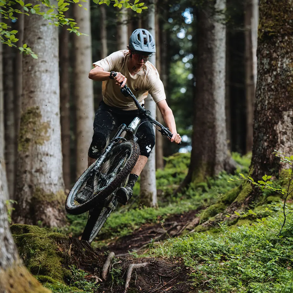BIXS E-Mountainbiker springt über Wurzeln auf Waldtrail