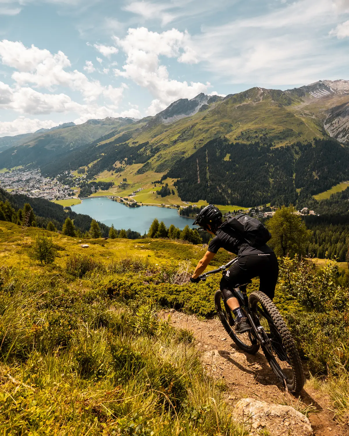 Fahrer auf Trail mit Blick auf Davosersee und Bergpanorama