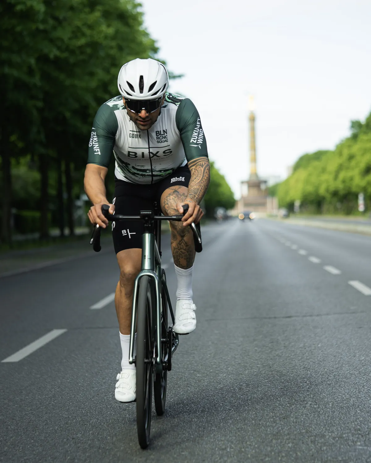 Martin C., Fahrer des BLN RCNG Squads, mit tätowierten Armen auf dem Rennrad in Berlin