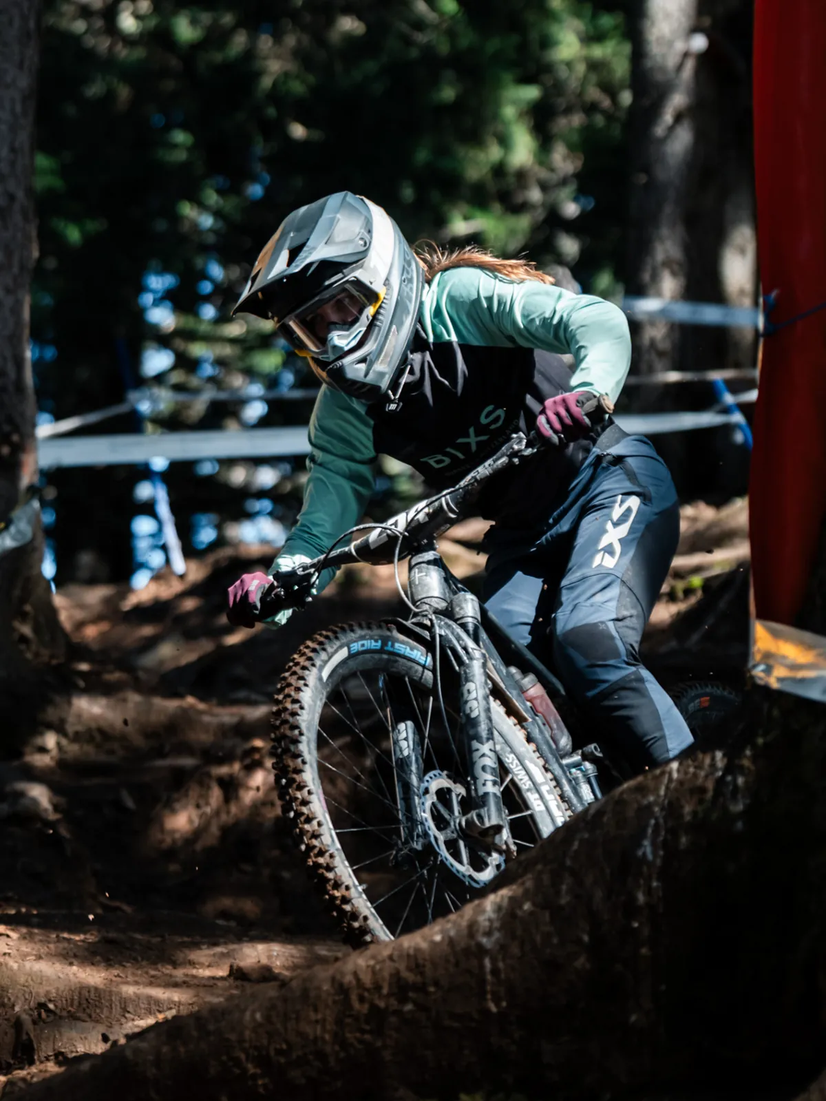 Fahrerin der BIXS Traction Crew im Downhill-Einsatz auf einer Wurzelpassage