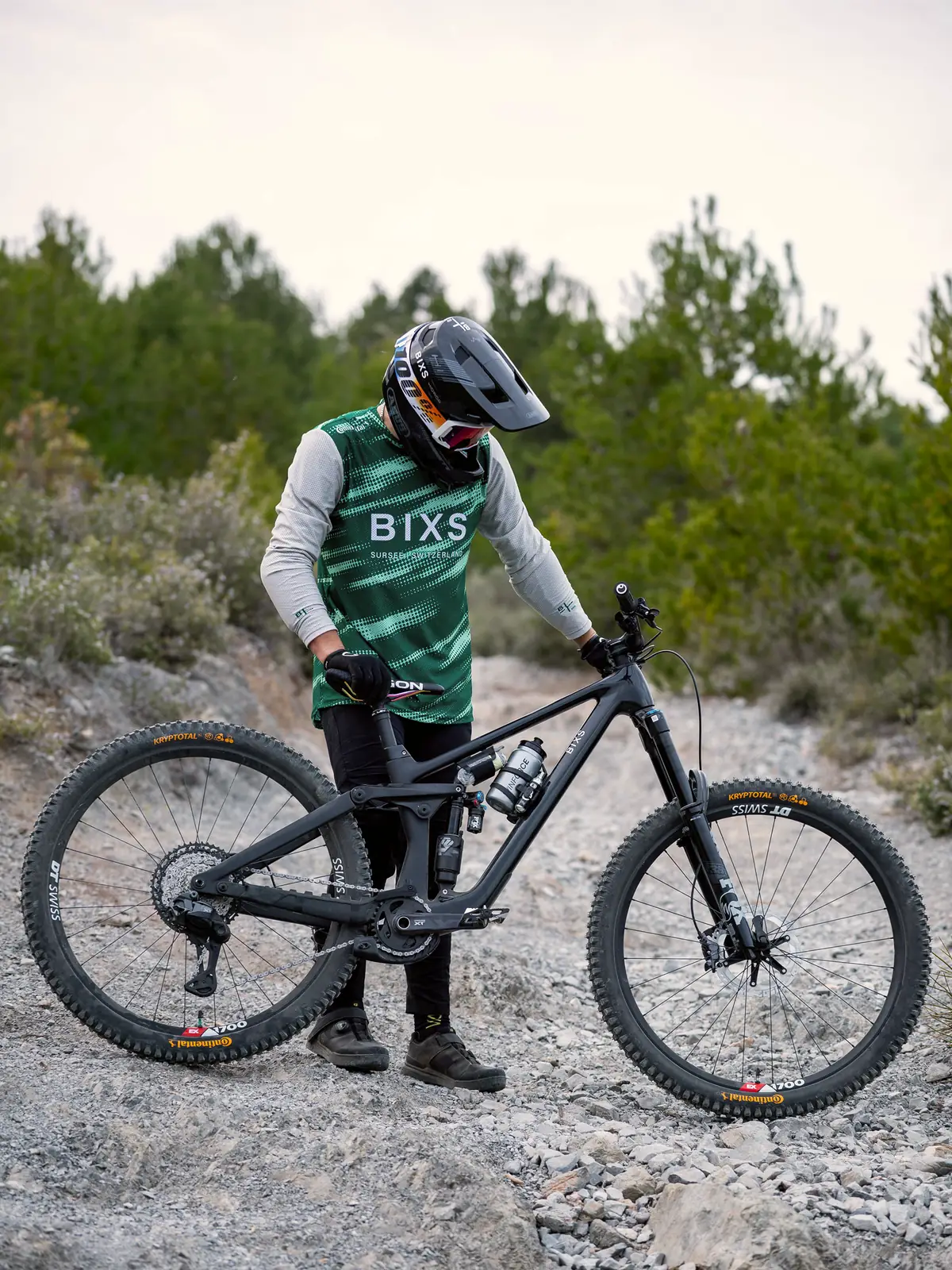 Fahrer des BIXS Enduro Race Teams beugt sich über sein Bike