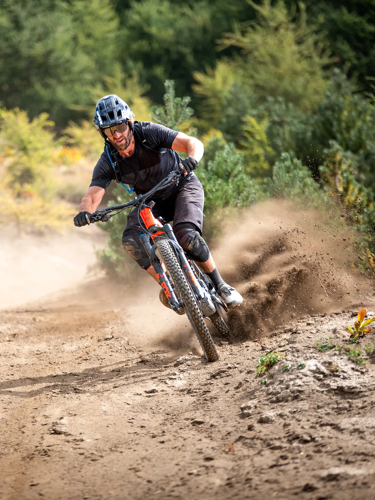 BIXS Mindsetter Fahrer neigt sein Lane Mountainbike dynamisch durch eine staubige Kurve