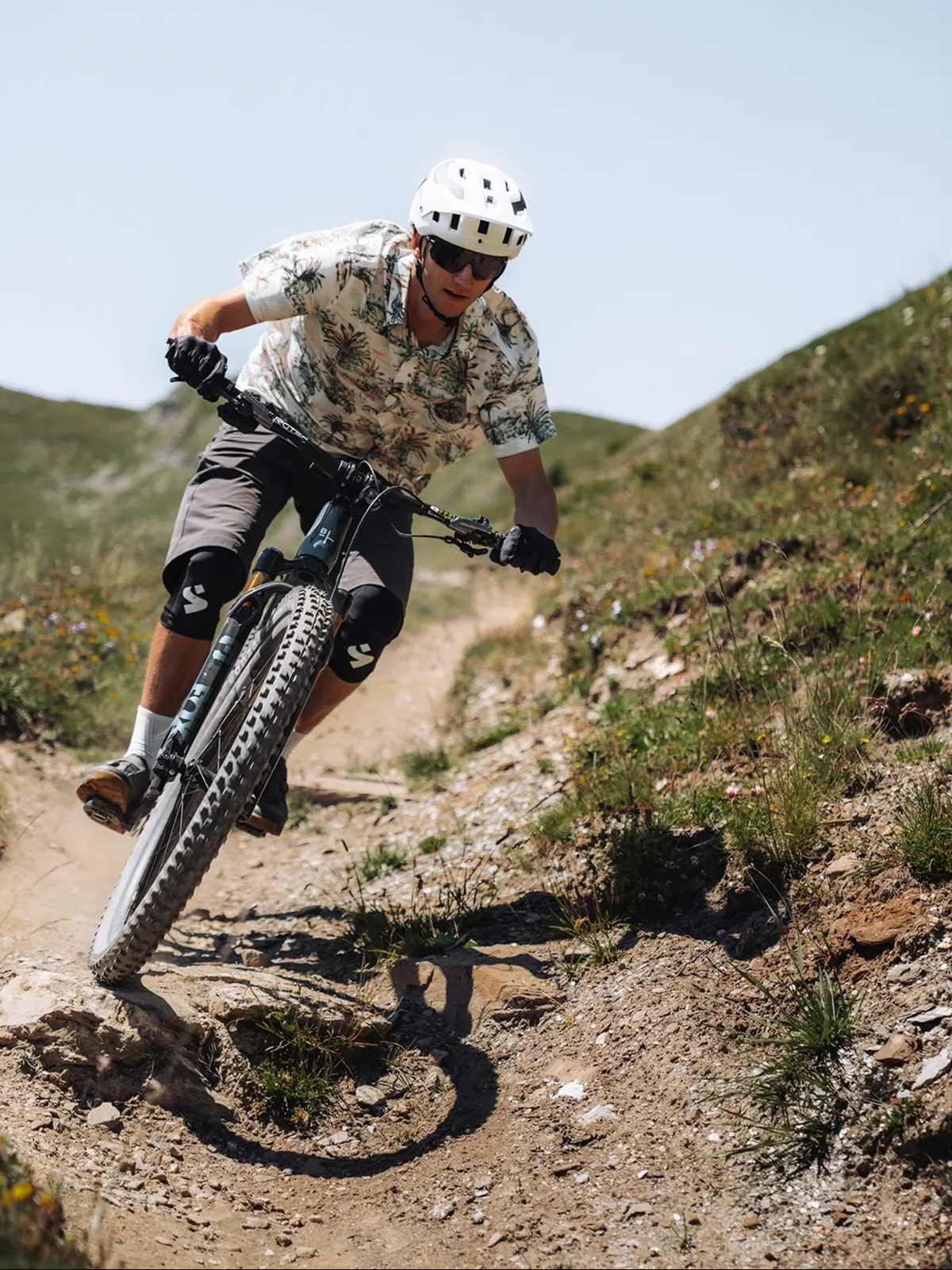 BIXS Enduro-Mountainbike in dynamischer Fahrt durch eine Trailkurve in den Bergen