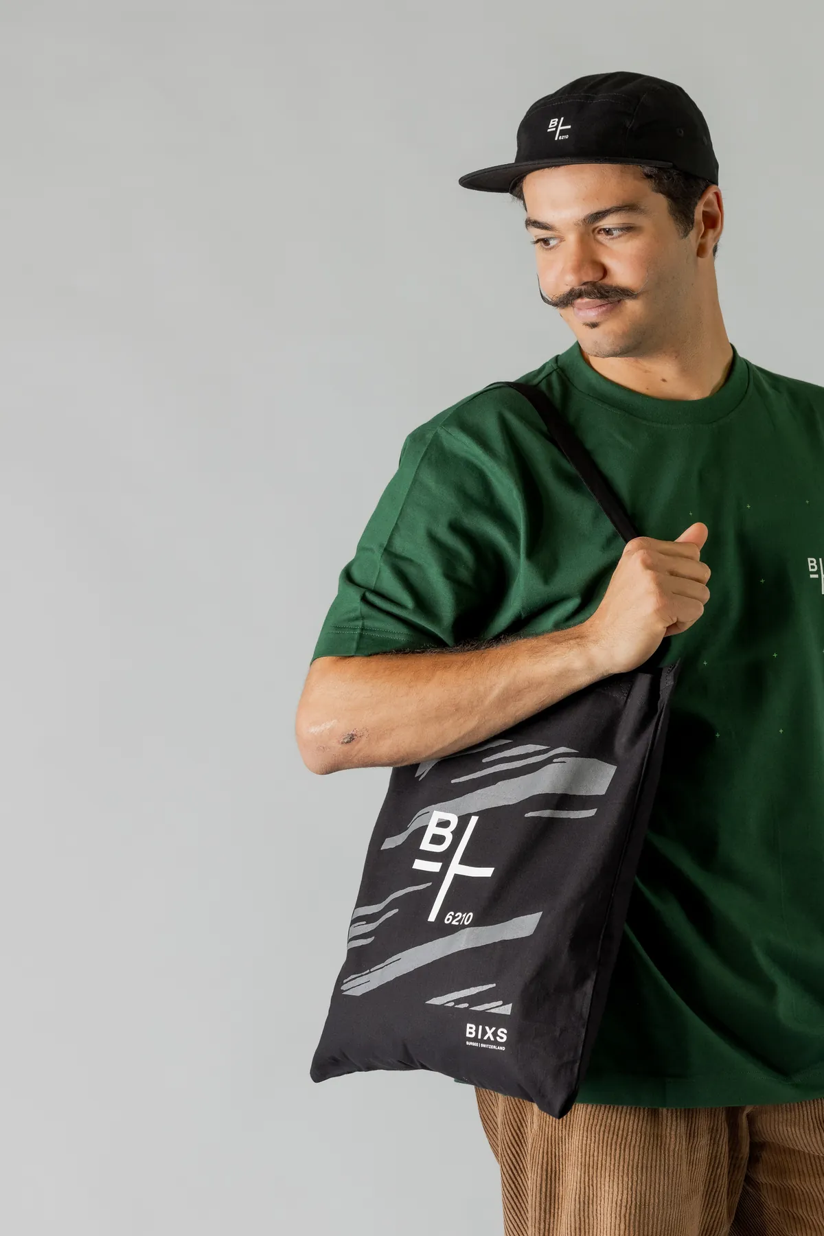 BIXS Crew Wear Look mit grünem T-Shirt, schwarzer Cap und Tote Bag im Studio
