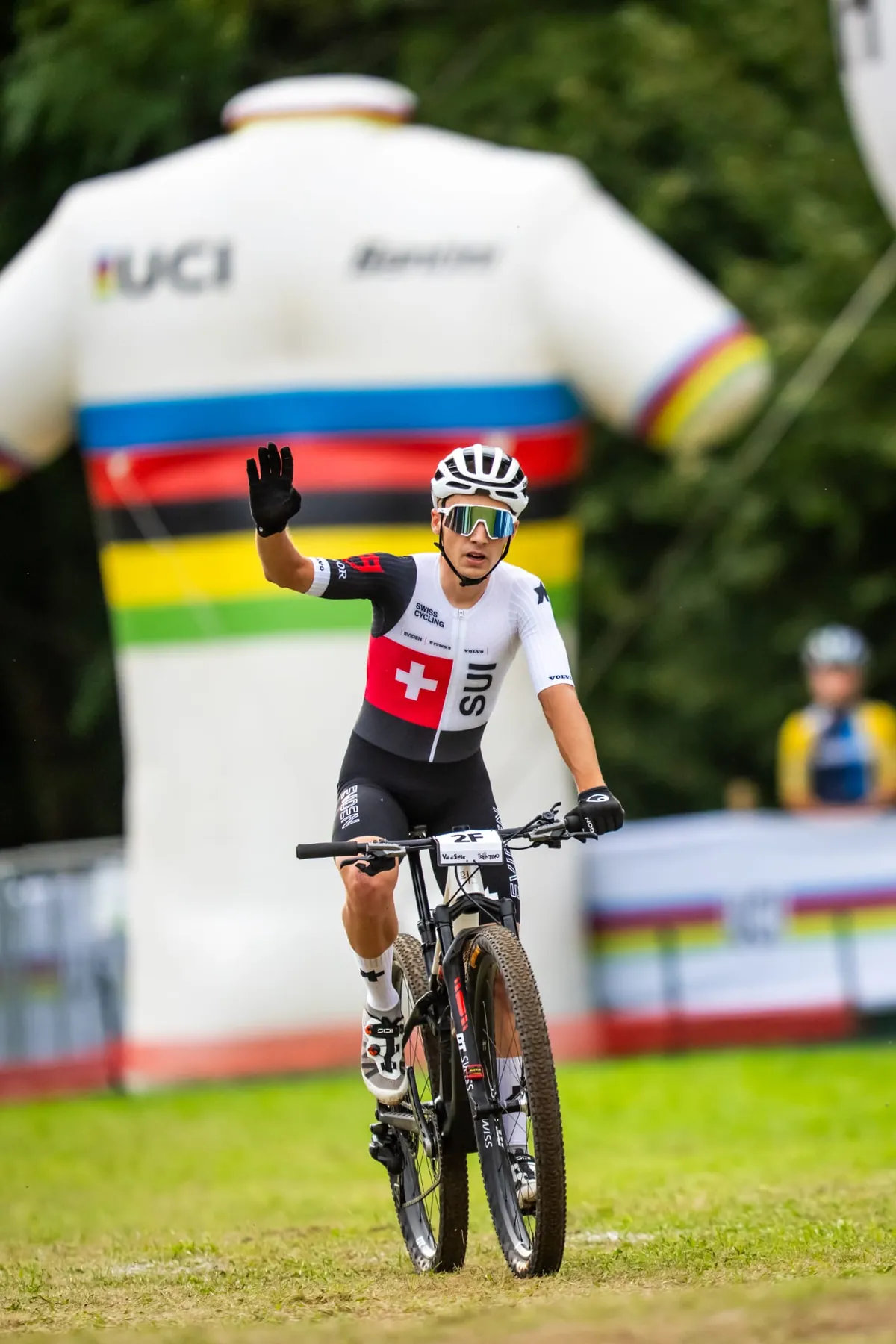 Schweizer Cross-Country-Fahrer im SUI-Trikot winkt bei der Zieleinfahrt der Mixed-Staffel in Val di Sole