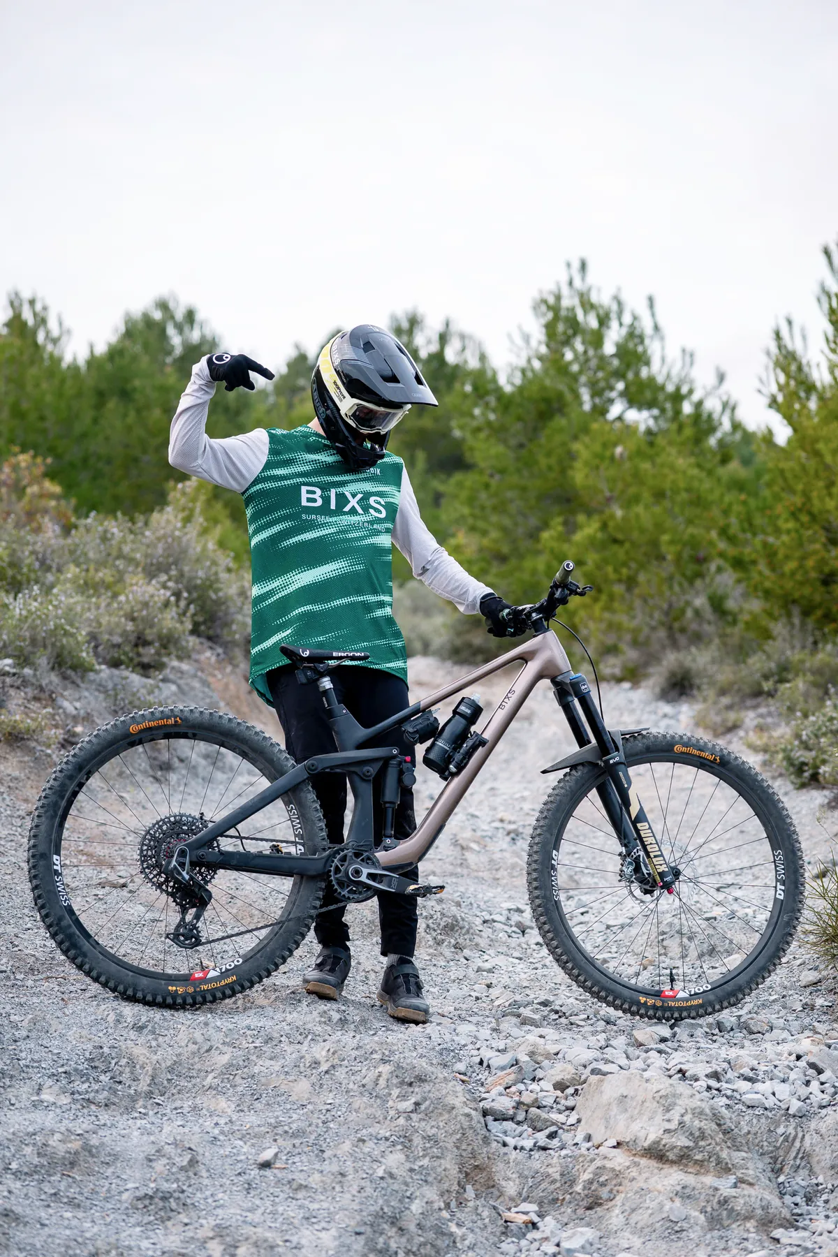 BIXS Enduro-Mountainbike in Roségold, Fahrer zeigt auf das Bike