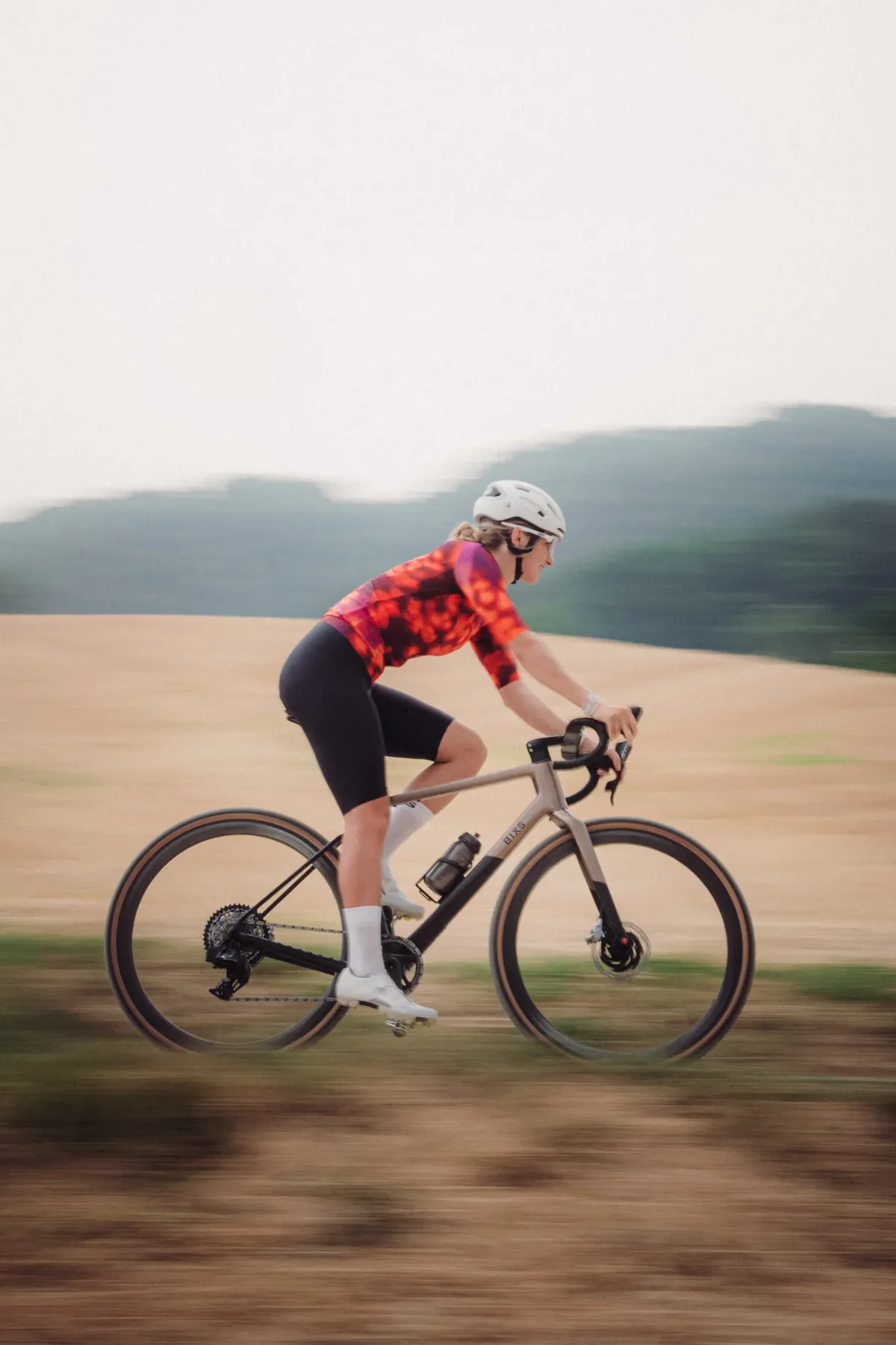 BIXS Mindsetter Fahrerin auf Gravelbike in Bewegungsunschärfe