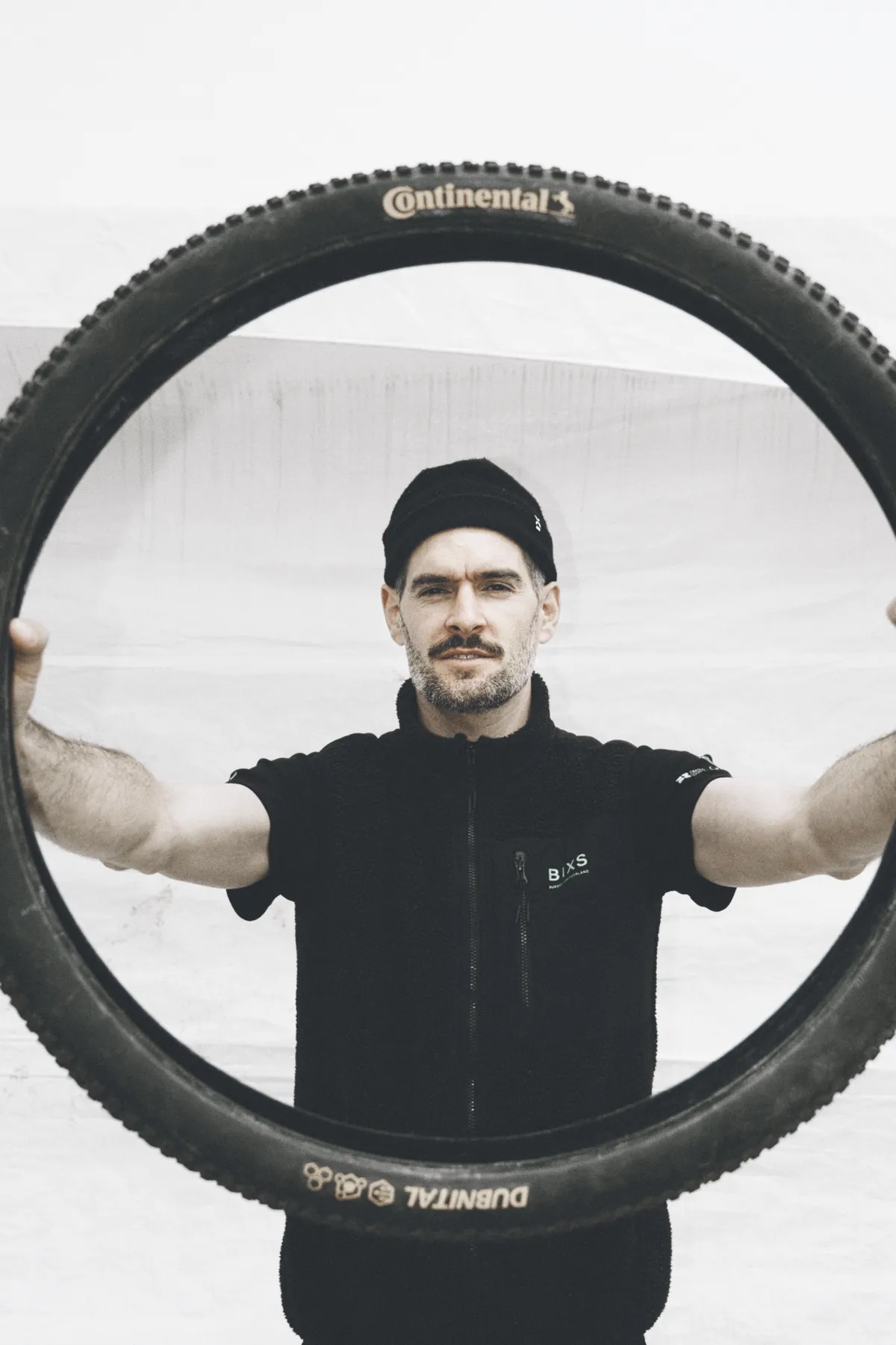 Lukas Winterberg, Mechaniker im BIXS Race Team, blickt durch einen Reifen in die Kamera