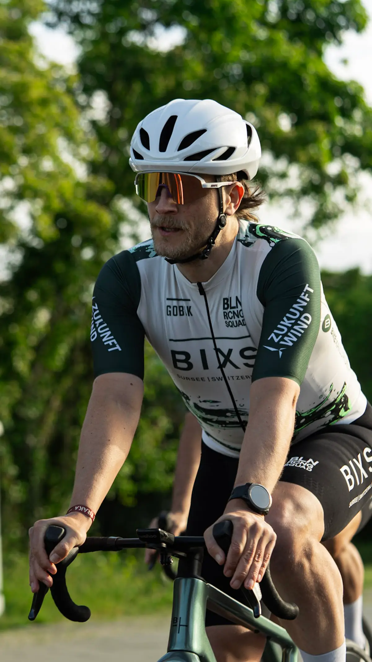 Fahrer mit Sonnenbrille im Teamtrikot beim Fahren, Nahaufnahme