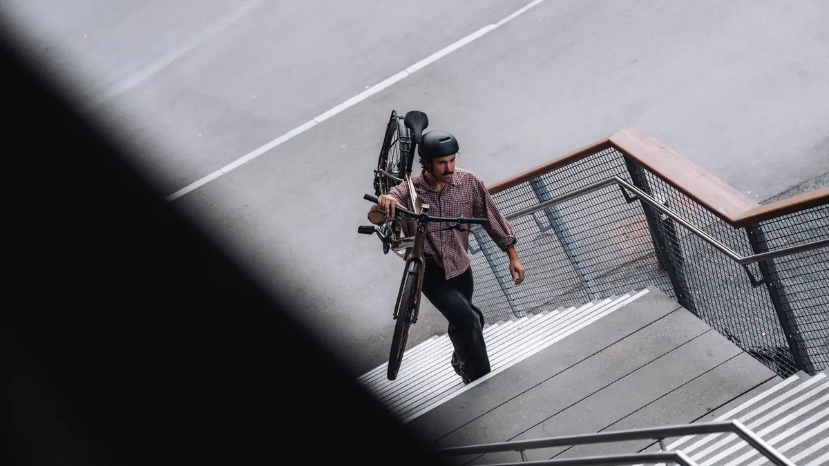 Mann trägt BIXS Urban Mobility Bike eine Treppe hinunter in der Stadt