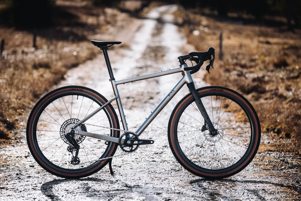 BIXS Traverse Gravelbike in Seitenansicht auf nassem Feldweg