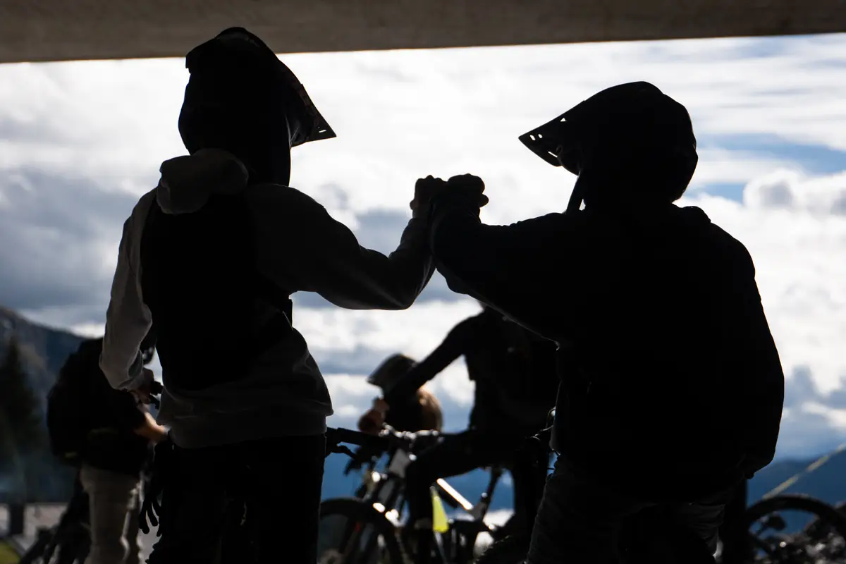 Silhouette von zwei Fahrern der BIXS Traction Crew beim Fist Bump vor Bergpanorama