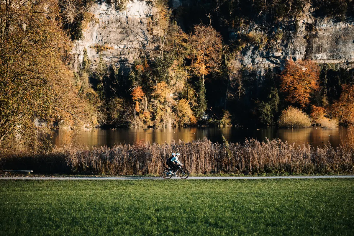 Zwei Fahrer mit BIXS Traverse fahren einem Bergsee entlang.